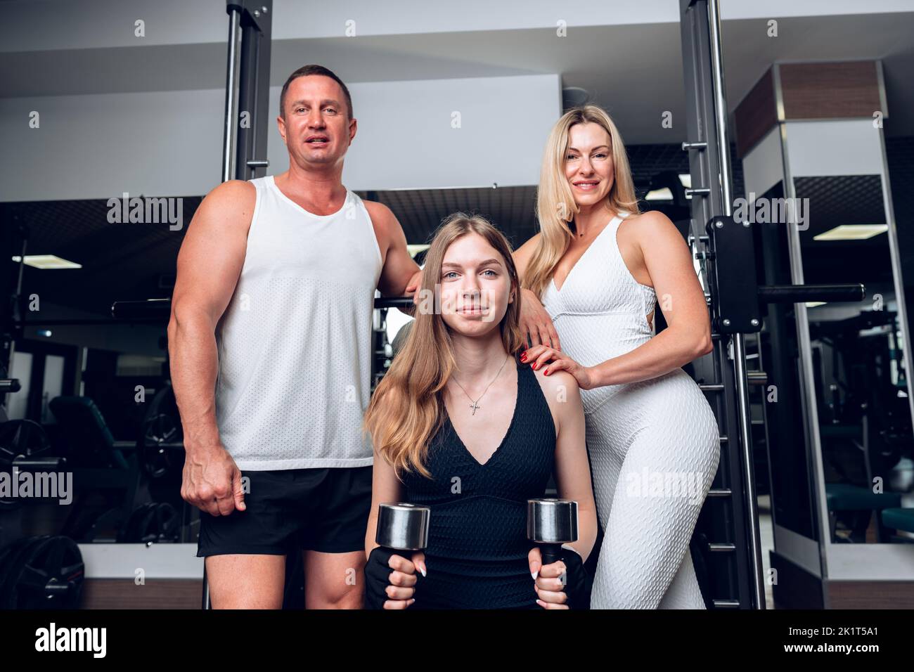 Mother, father and teen daughter training together in a gym Stock Photo ...