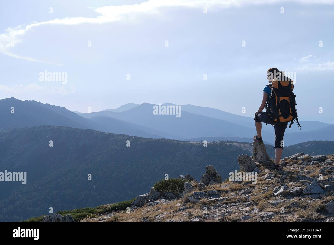 A Female traveler with backpack admiring mountains Stock Photo
