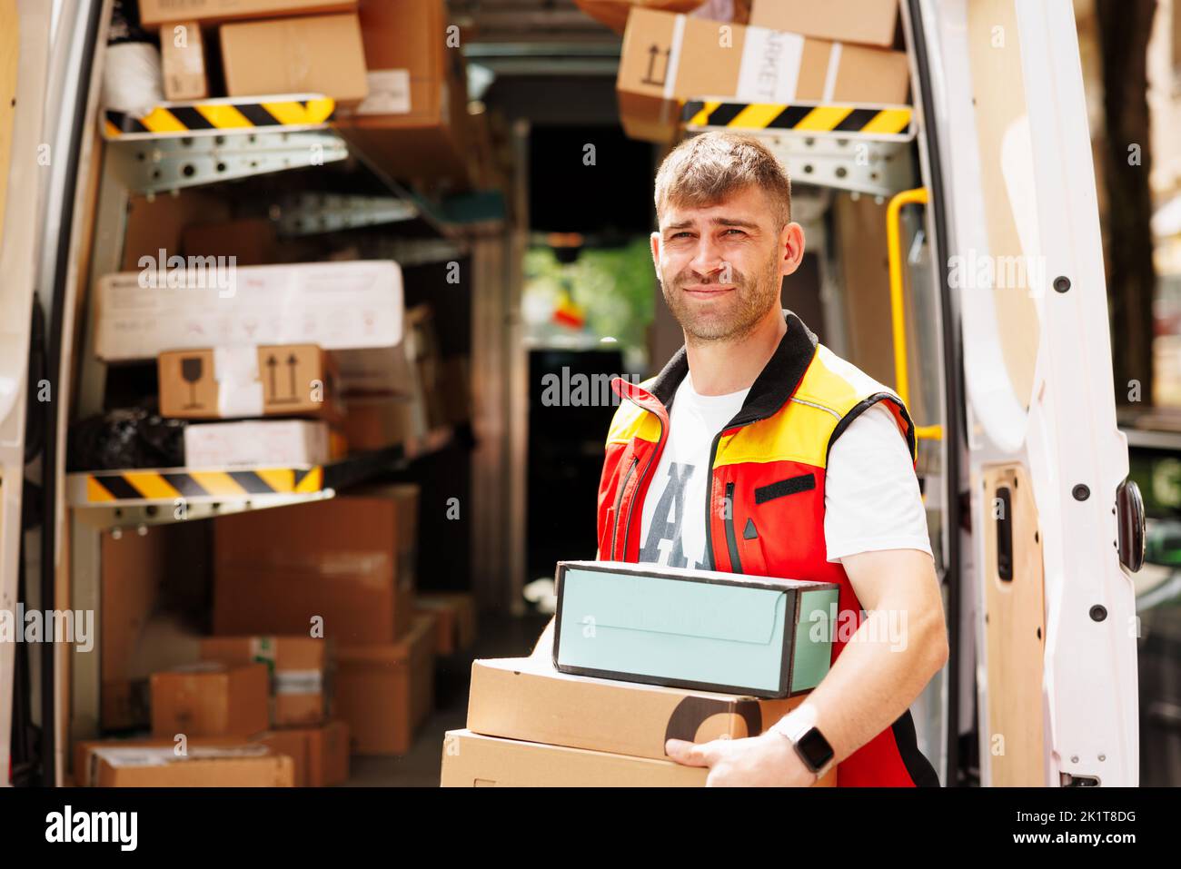 The man smiles and waits for the person to come to deliver the boxes Stock Photo