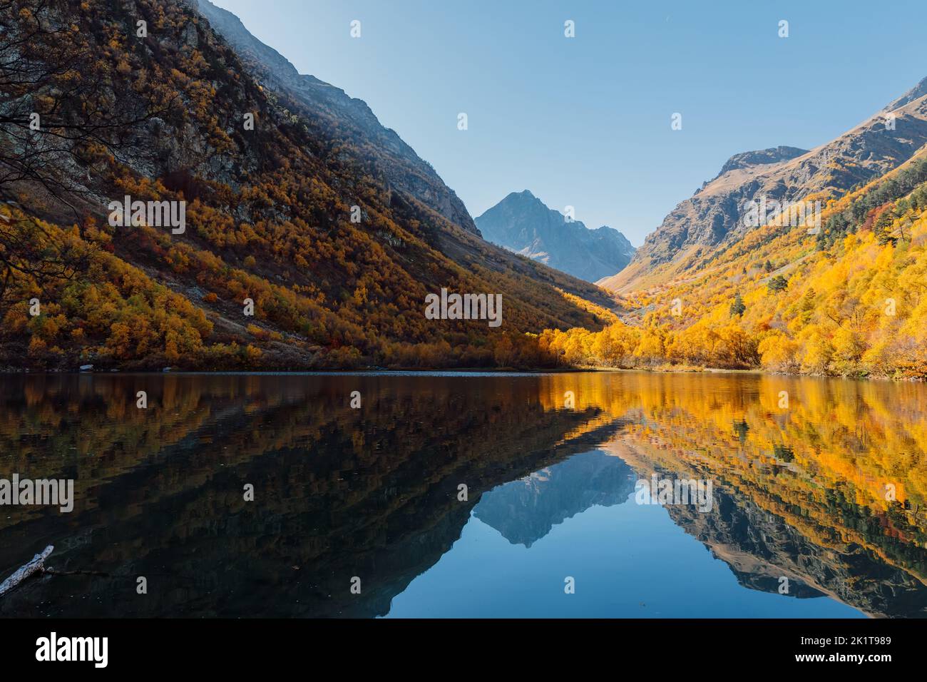 Mountain lake with glassy water and autumnal trees Stock Photo - Alamy