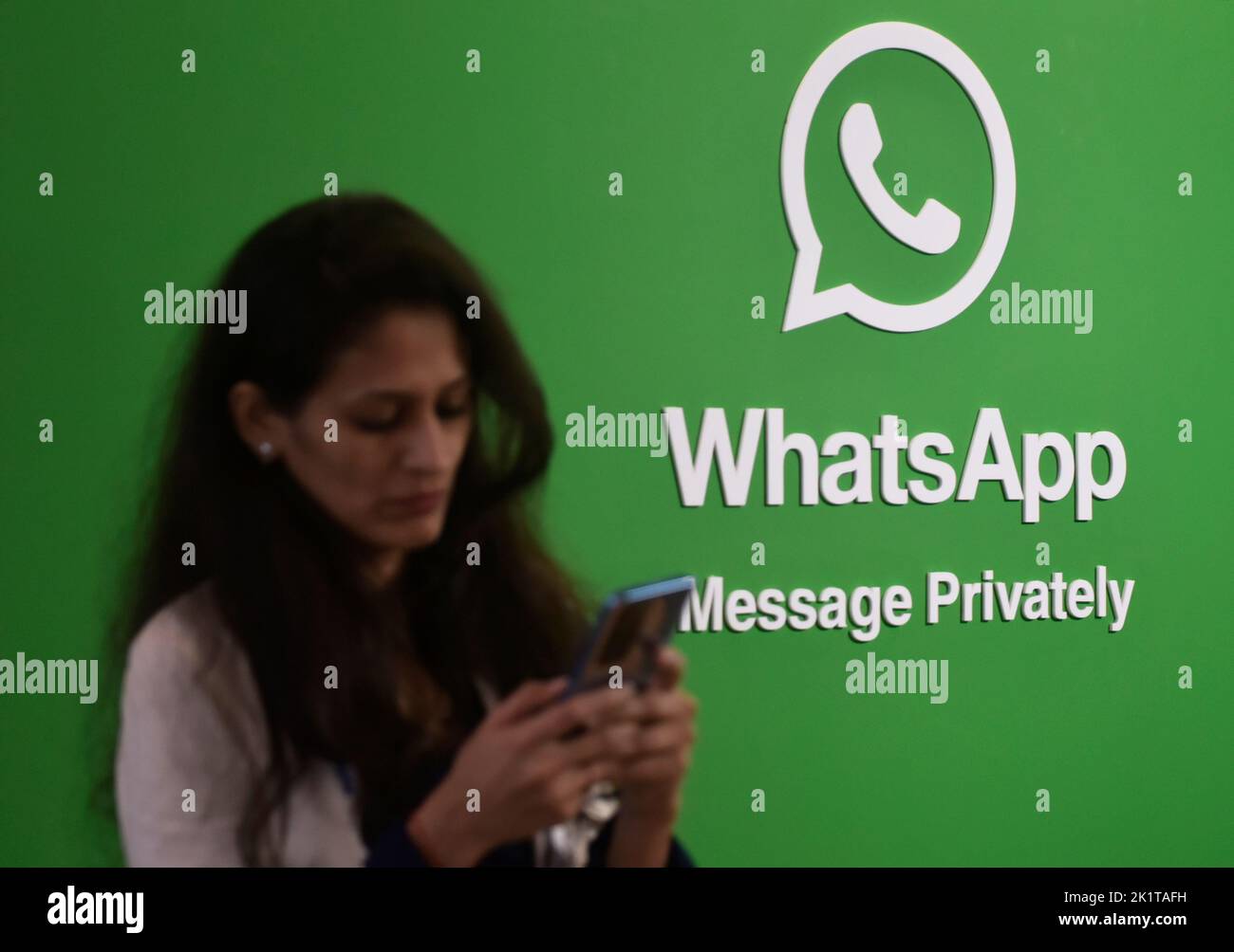 Mumbai, Maharashtra, India. 20th Sep, 2022. A woman uses her phone next to a logo of the WhatsApp application during Global Fintech Fest in Mumbai, India, 20 September, 2022. (Credit Image: © Indranil Aditya/ZUMA Press Wire) Stock Photo