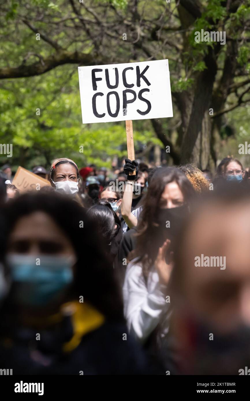 A protestor holds a 'Fuck Cops' sign at an anti-police, Black Lives Matter protest following Regis Korchinski-Paquet's death in Toronto, Ontario. Stock Photo