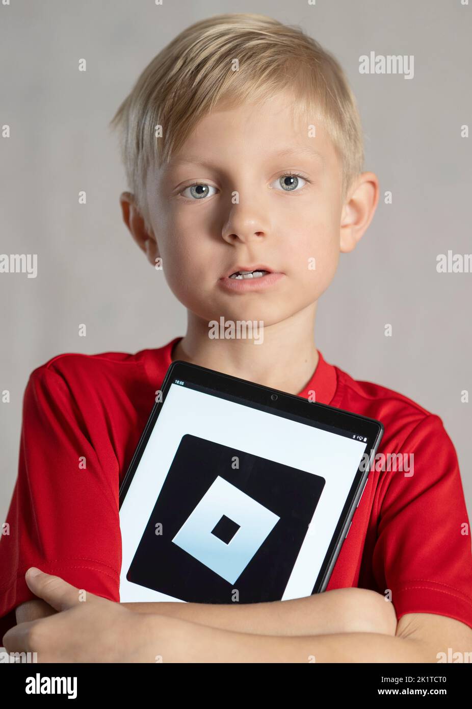 Studio portrait of caucasian boy in red t-shirt with tablet Stock Photo