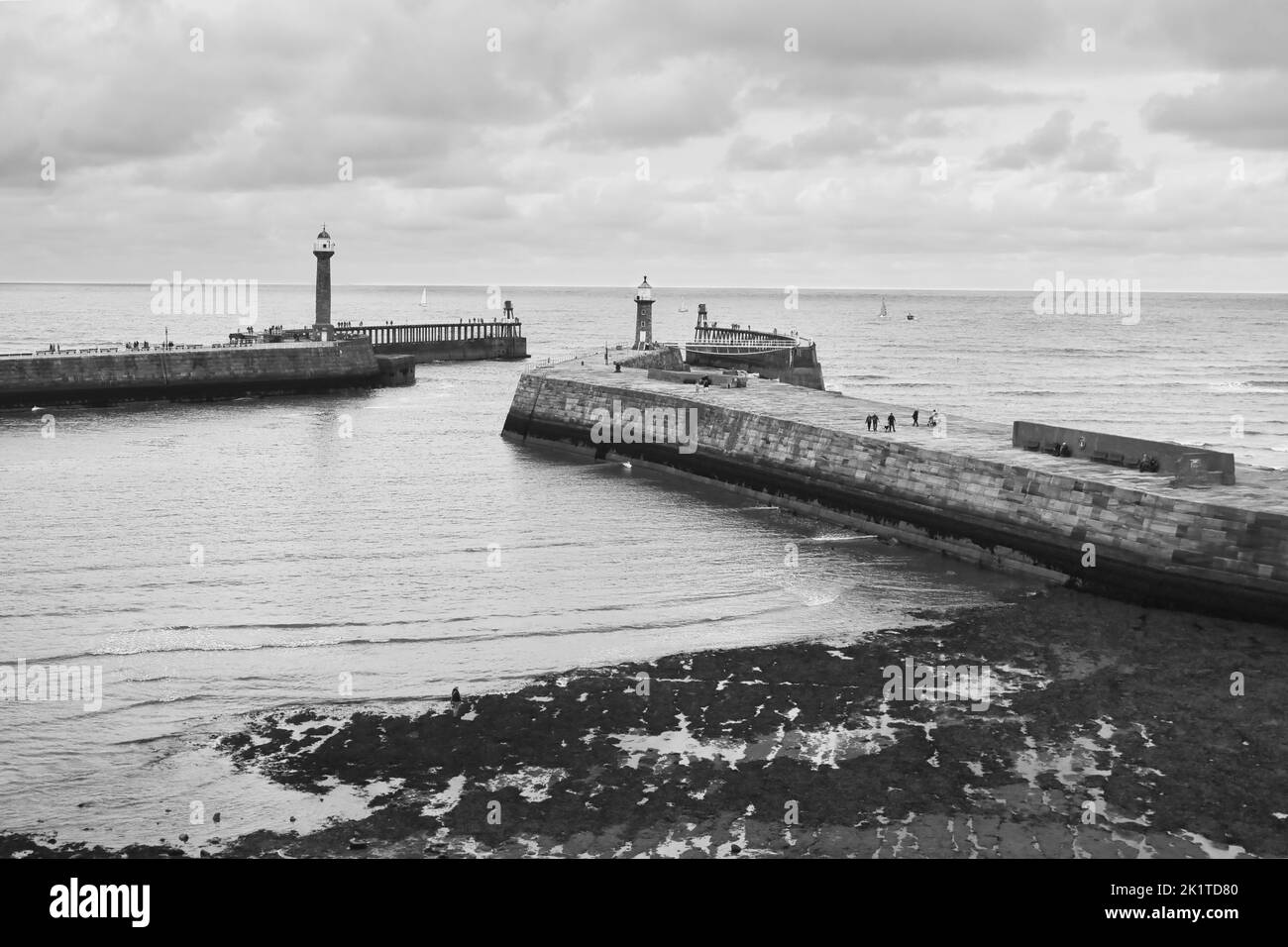 A grayscale shot of stone piers in Whitby, England Stock Photo