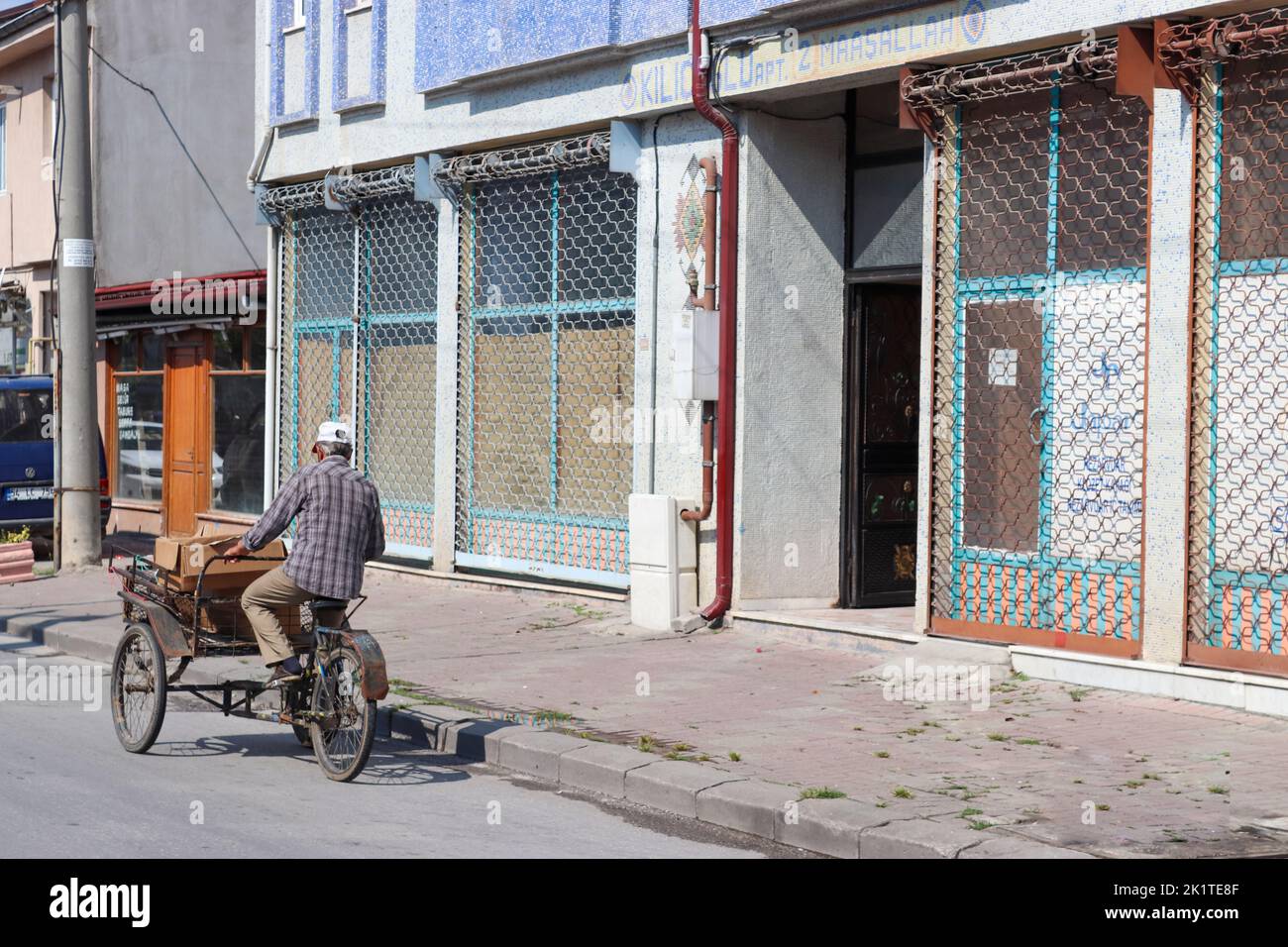 Sakarya, Turkey - August 2018  Sakarya street Scenes Life in Sakarya. The man crossing the street on his bicycle. 3 Wheel bike. Stock Photo