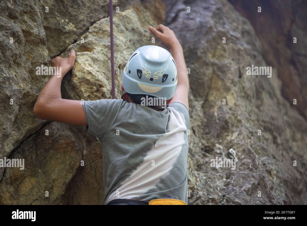 A man wearing a safety helmet while climbing rocks Stock Photo - Alamy