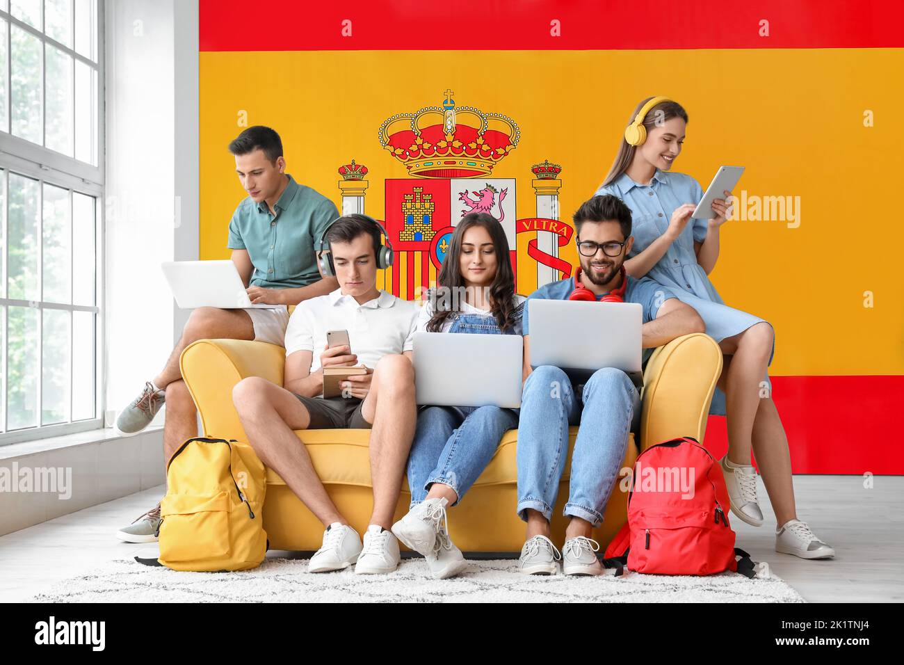 Students with modern devices indoors. Concept of studying Spanish Stock