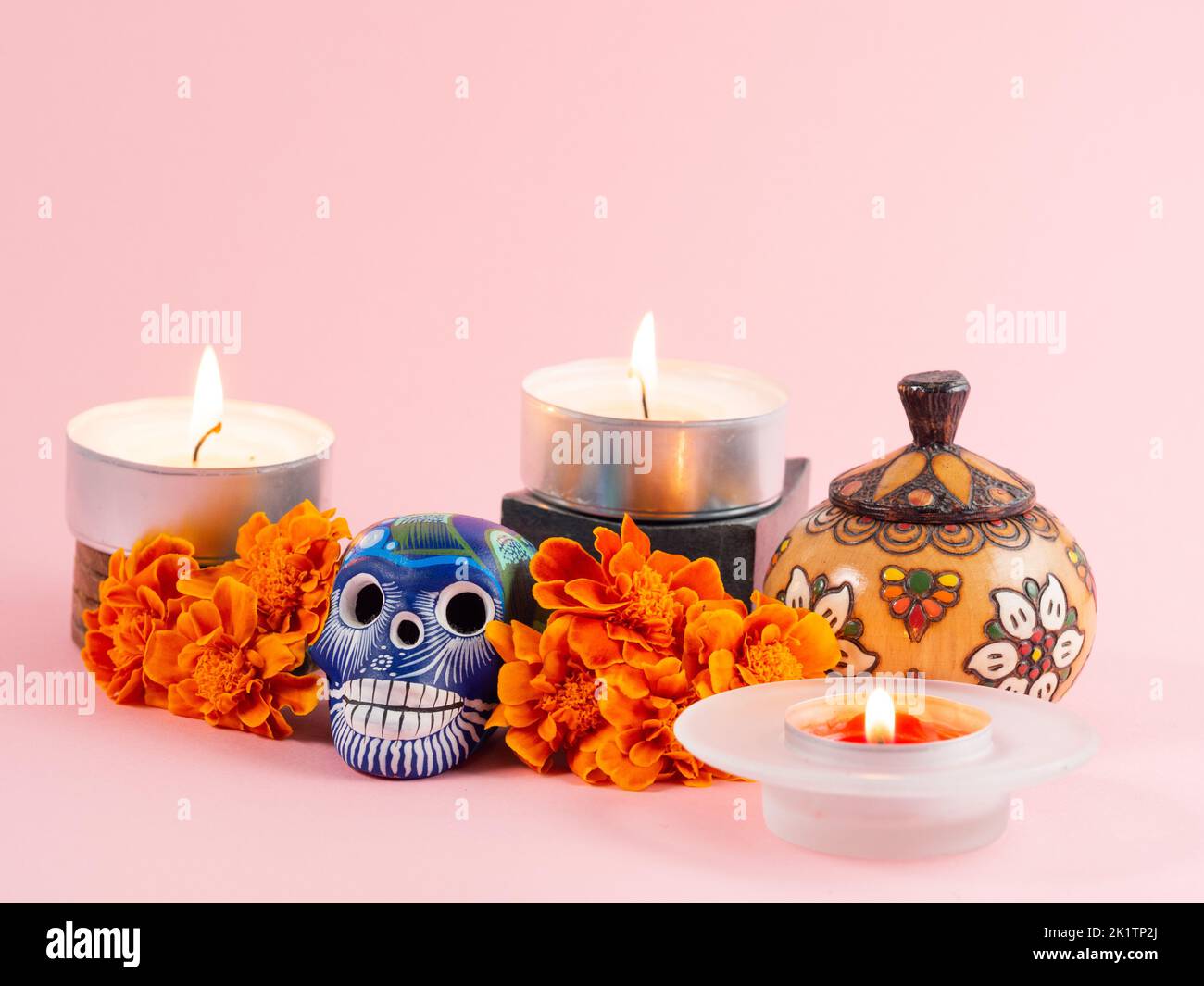 Spanish Mexican traditional autumn festival day of the dead typical Mexican skull with flowers painted on pink background , decorations and marigold f Stock Photo