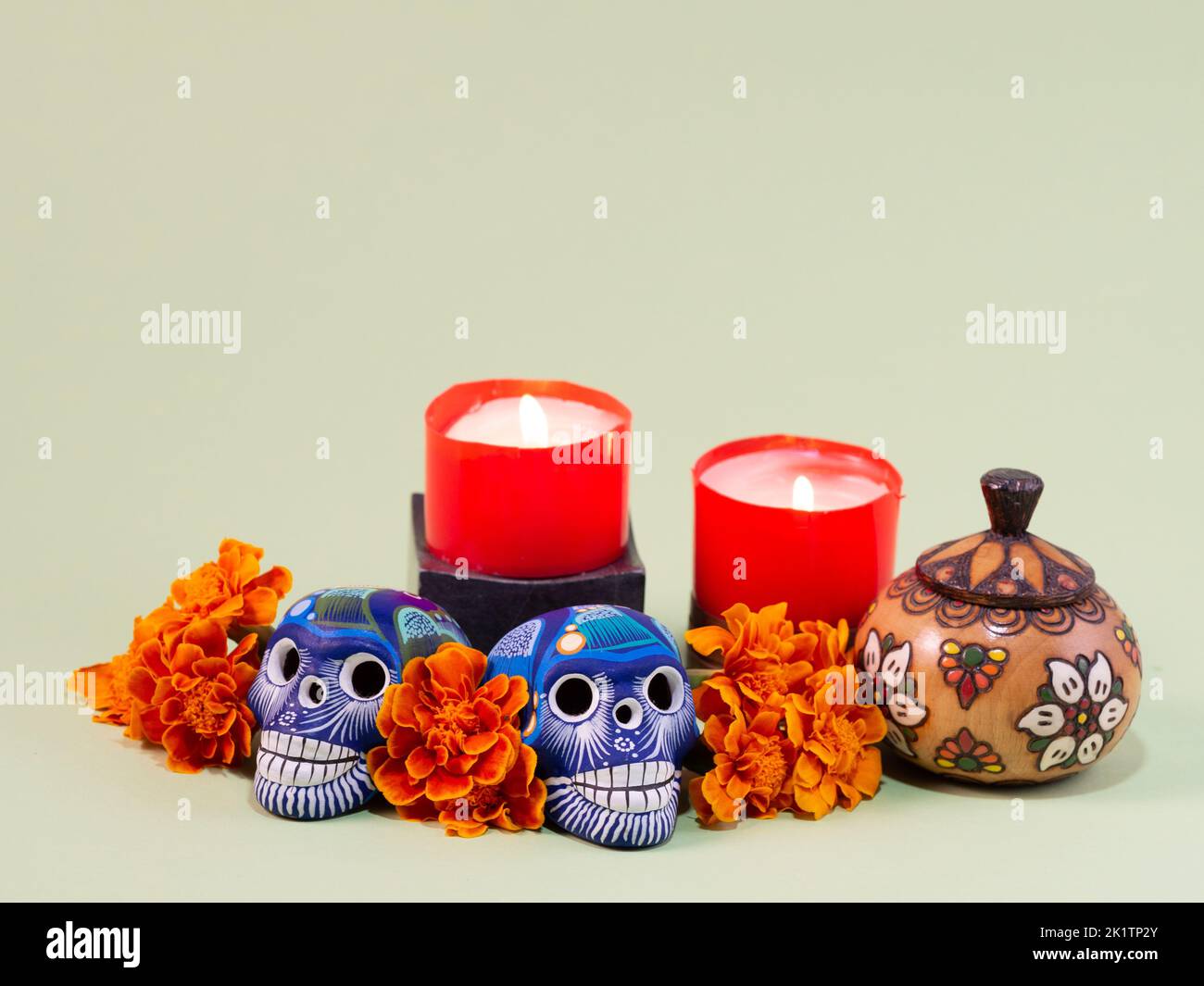 Spanish Mexican traditional autumn festival day of the dead typical Mexican skull with flowers painted on green background , decorations and marigold Stock Photo