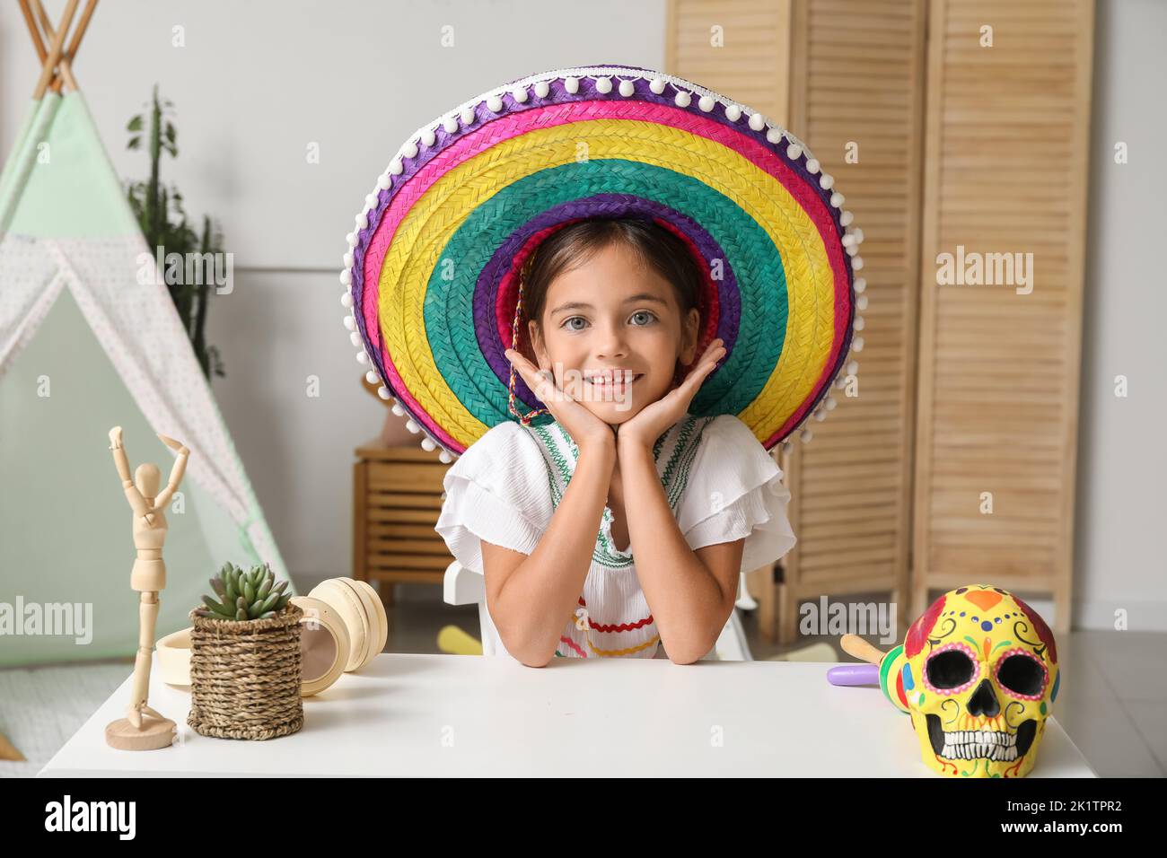 Little Mexican girl in sombrero hat sitting at home Stock Photo Alamy