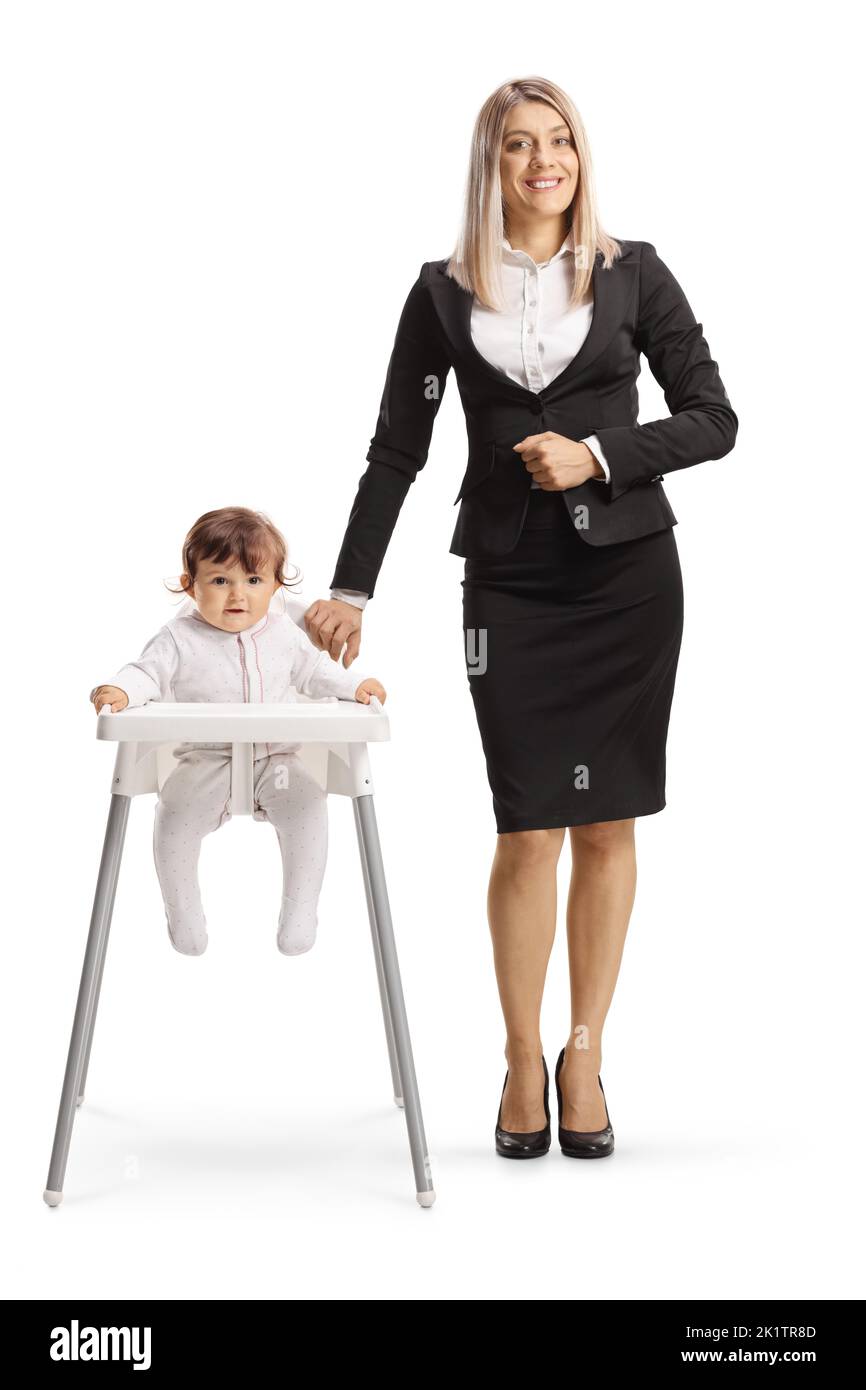 Full length portrait of a businesswoman standing next to baby in a feeding chair isolated on white background Stock Photo