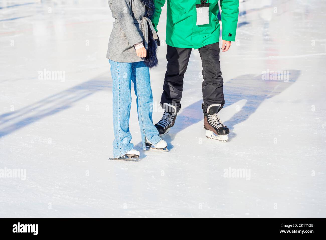 Abstract girl with trainer, sport coach for skating on rink in park. Winter activity, leisure, vacation Stock Photo
