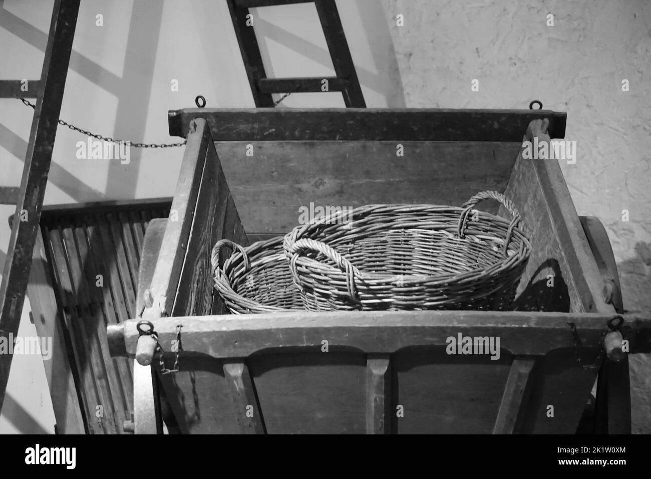A black and white shot of an old metallic cart with a basket in it Stock Photo