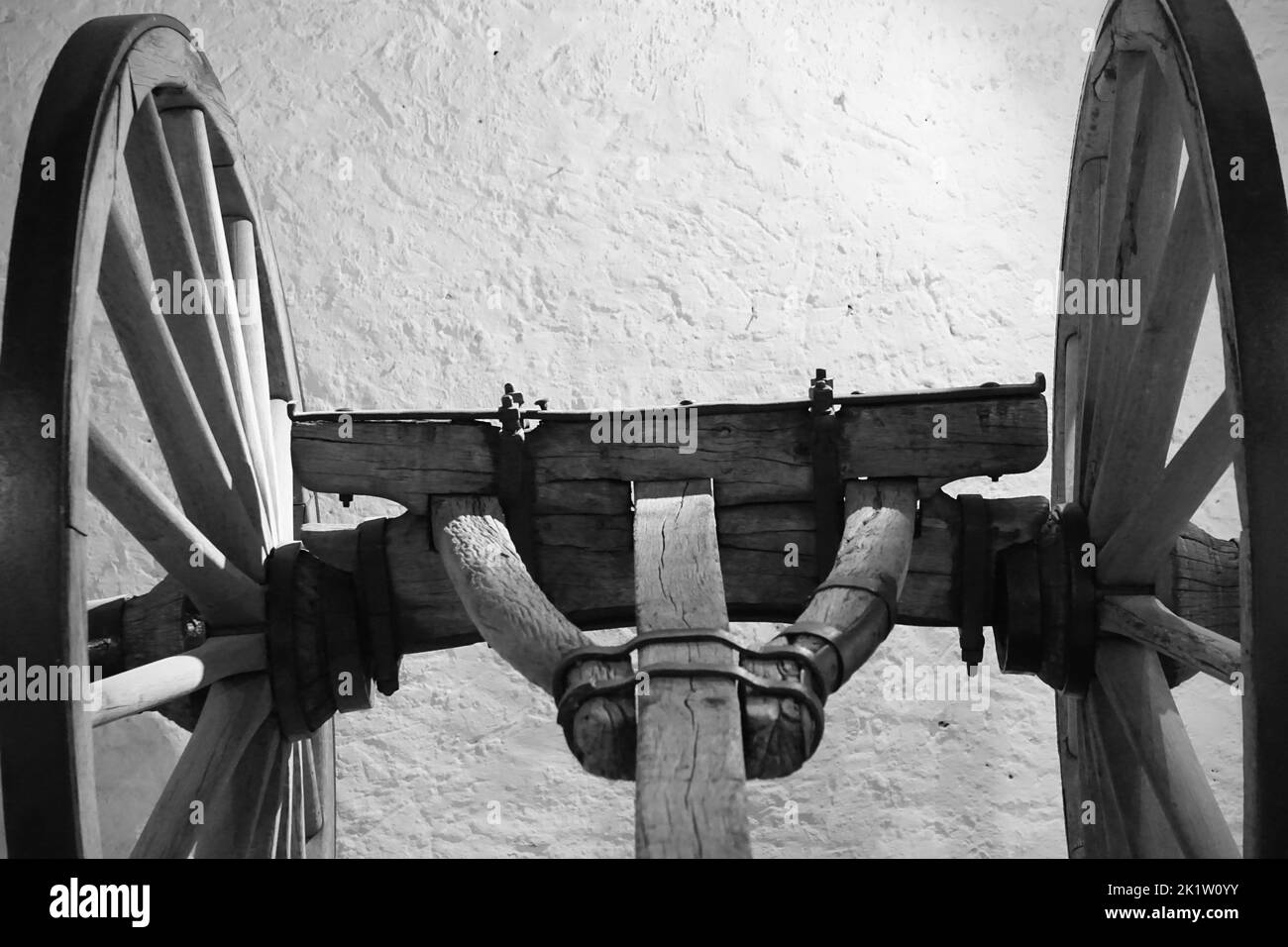A black and white shot of wheels of a rustic wooden cart Stock Photo