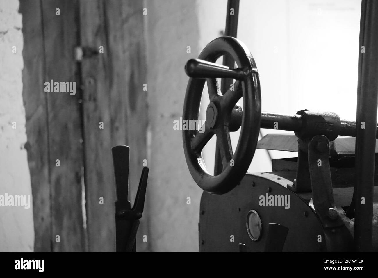 A black and white closeup of the steering wheel of a road roller Stock Photo