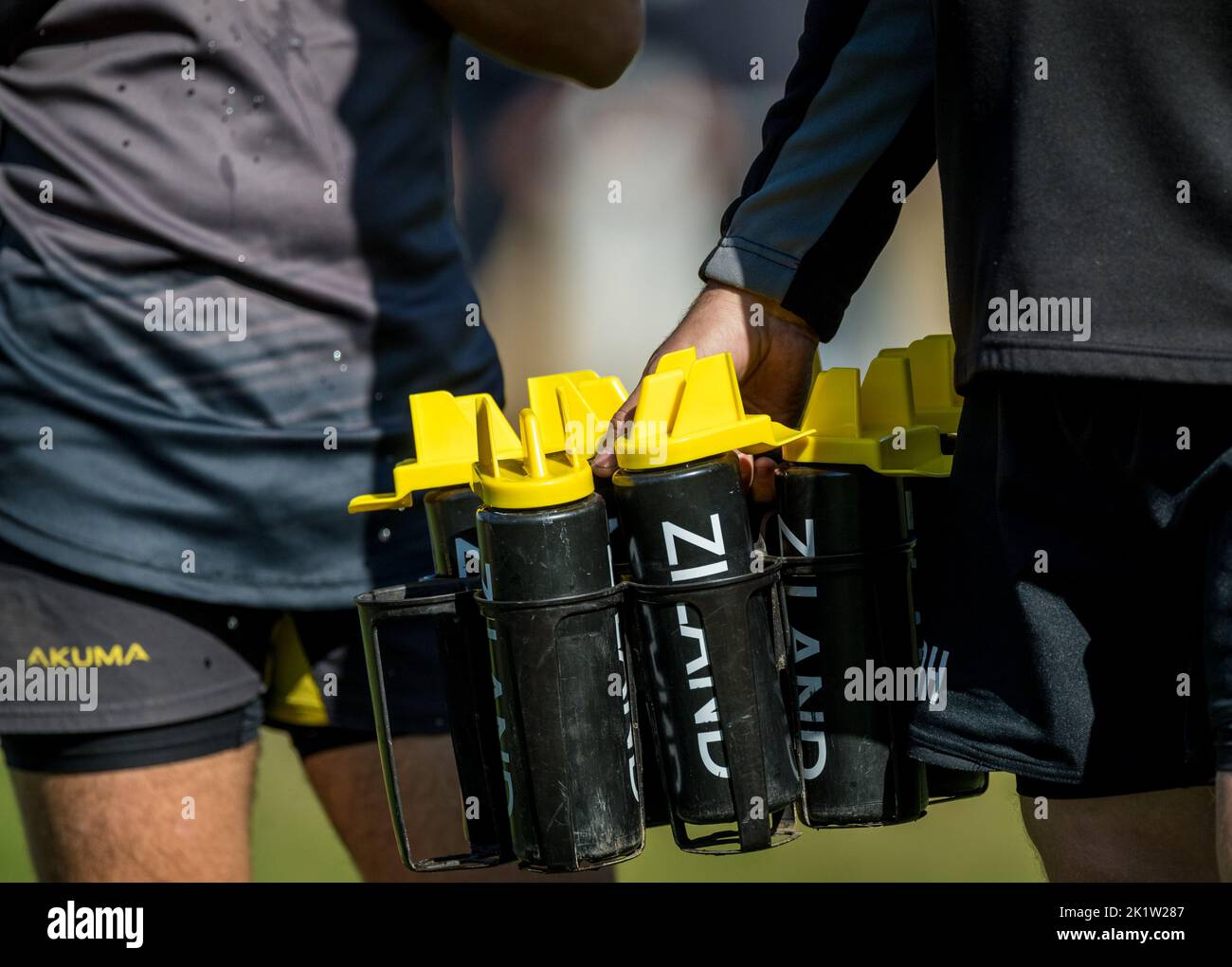 Rugby support team member carrying plastic Ziland water bottles. Stock Photo
