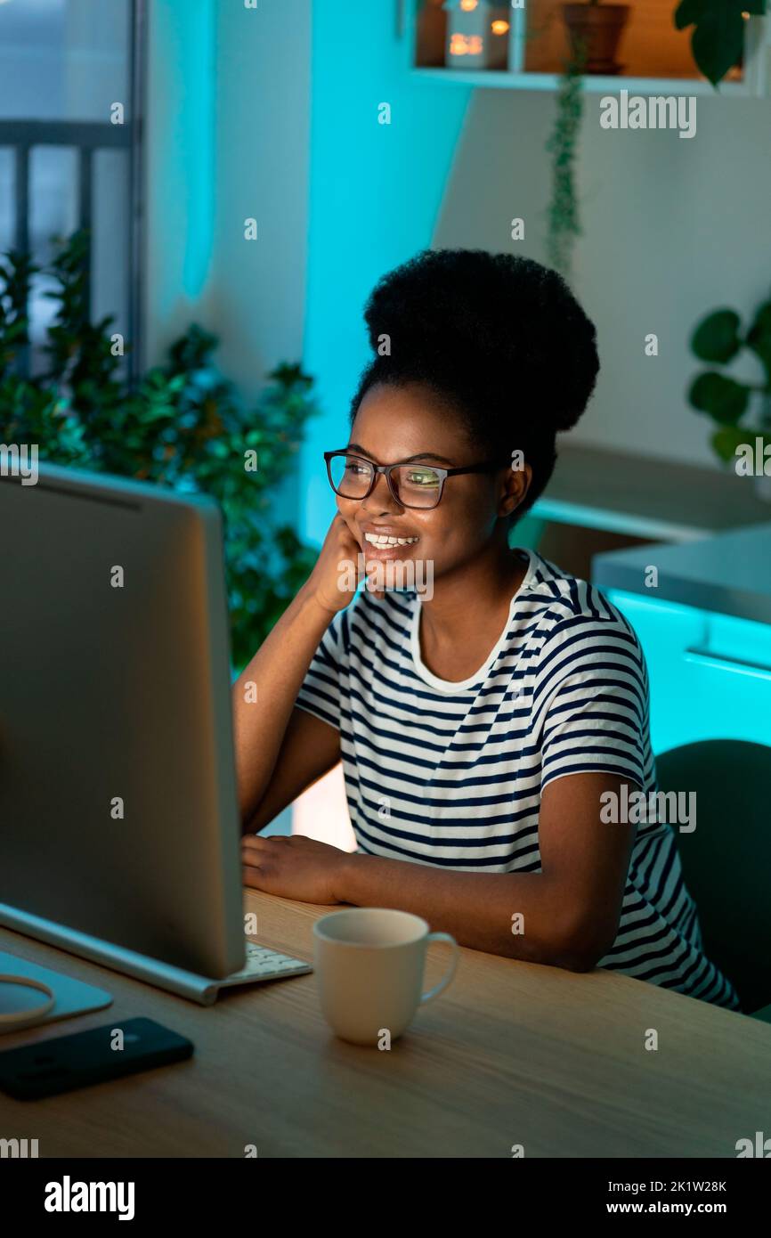 Happy successful black woman enjoy working from home on remote or freelance website or app project Stock Photo