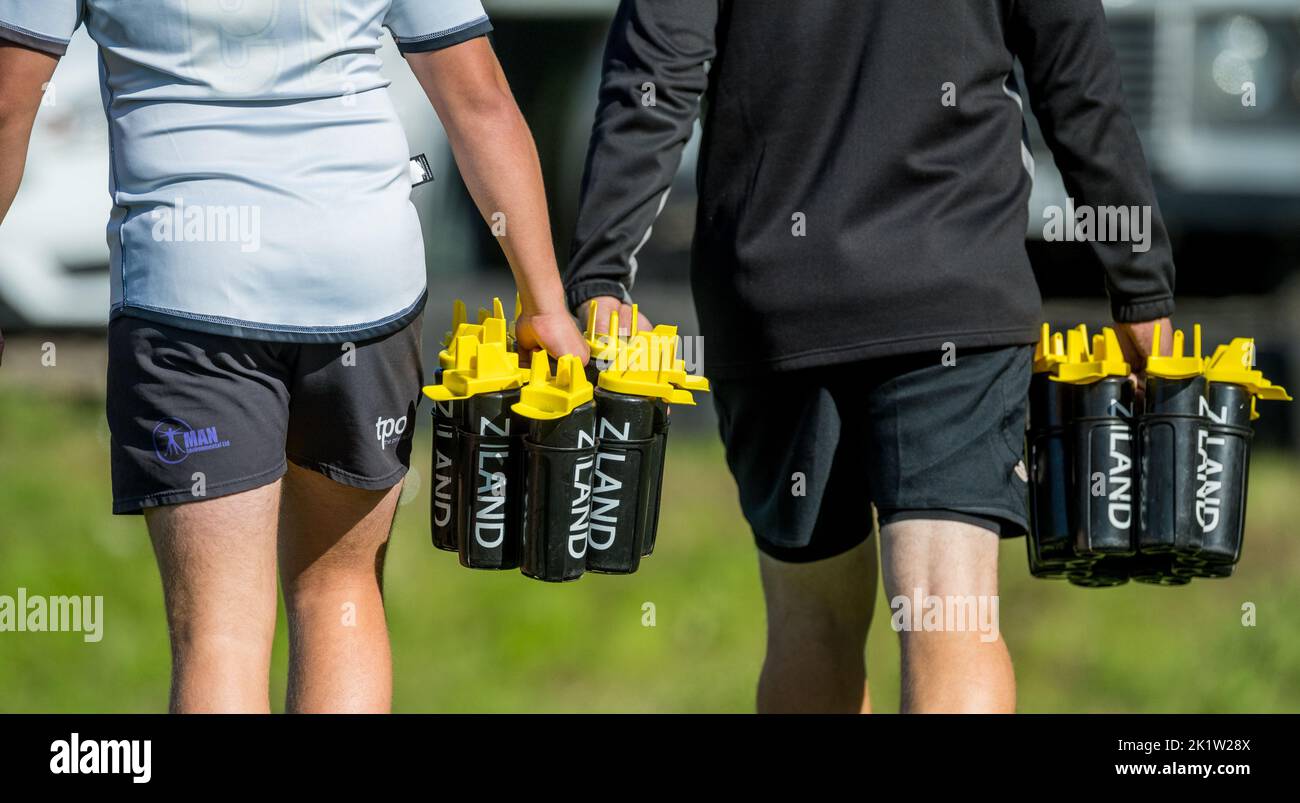 Rugby support team member carrying plastic Ziland water bottles. Stock Photo