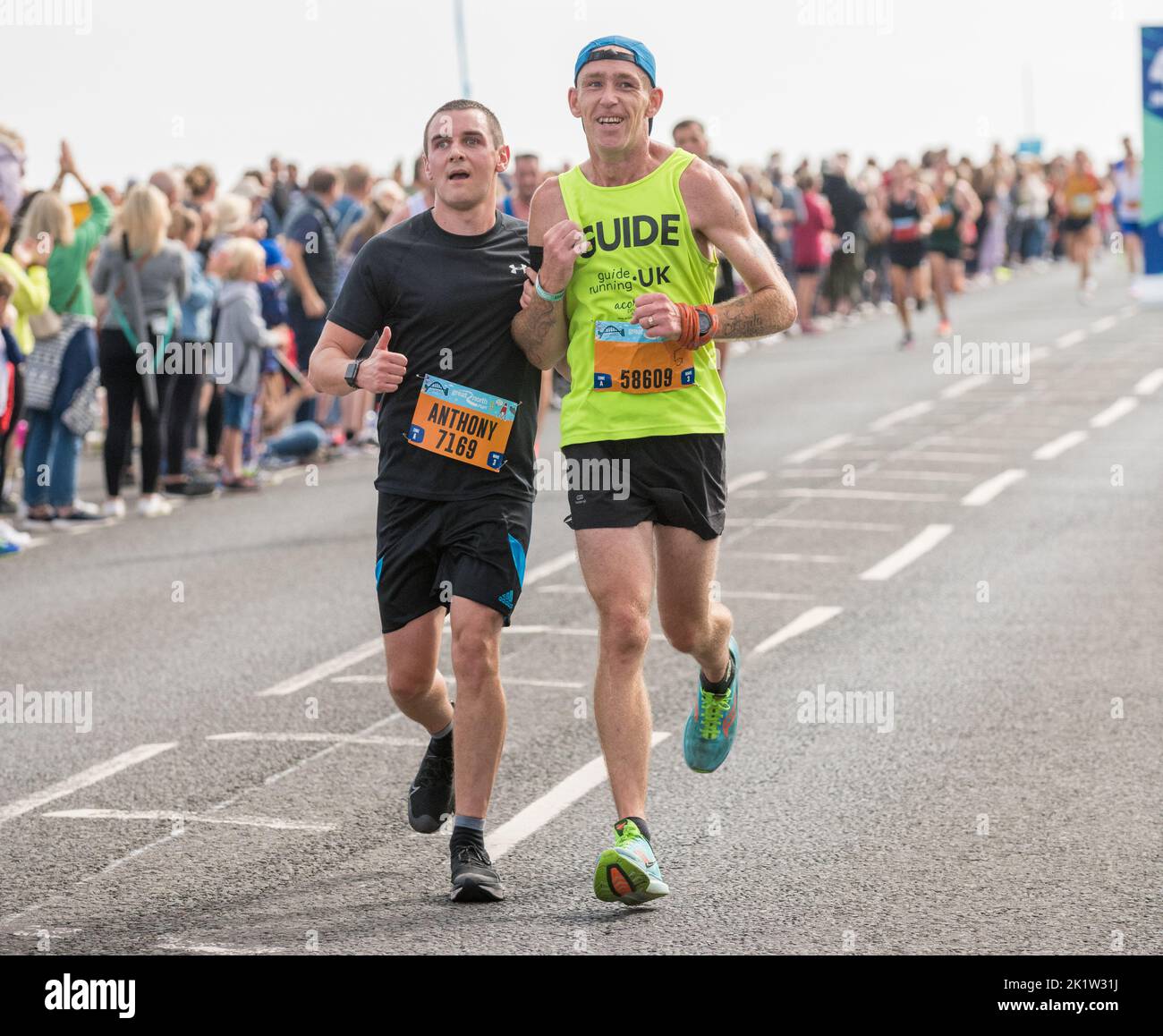 Runner from the Guide Running uk organisation help to support a runner  taking part in the 2022 Great North Run half marathon Stock Photo