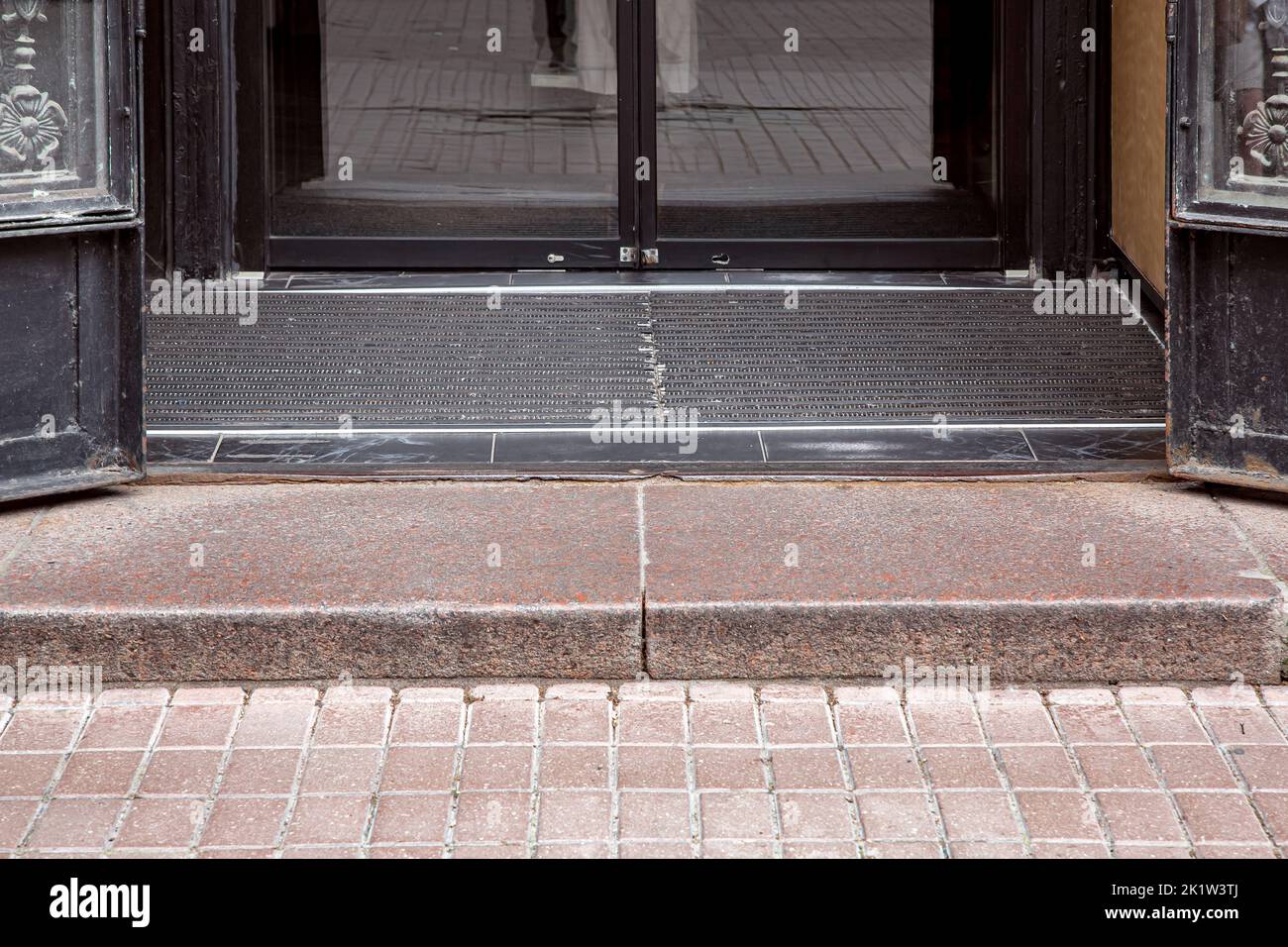 granite threshold at entrance to open iron doors through foot mat to