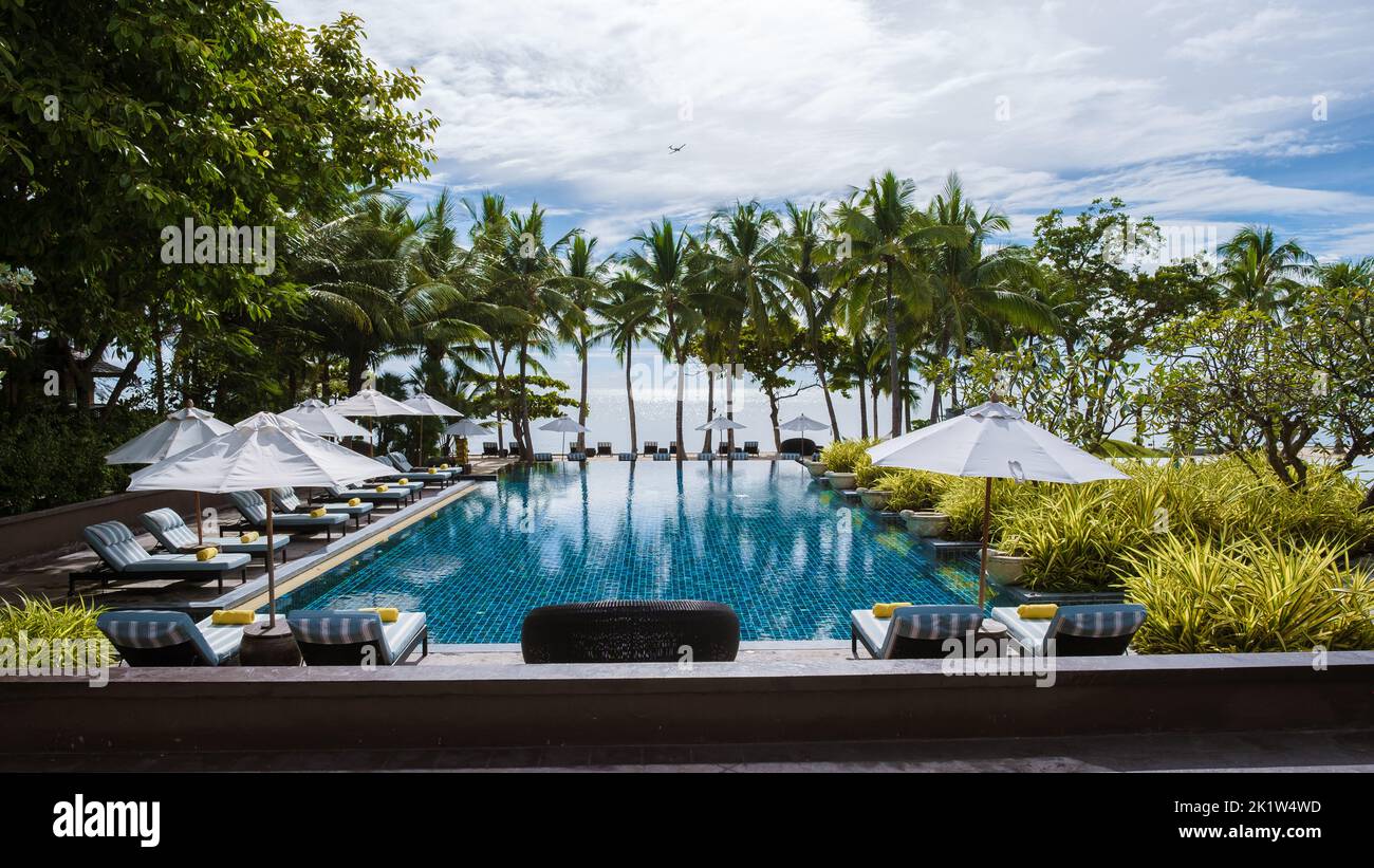 tropical pool with palm trees and beach bed chairs at a luxury resort ...