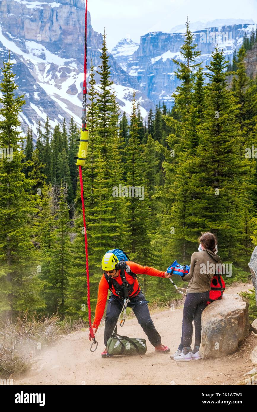 Search & Rescue paramedic evacuating injured hiker via helicopter; Lake Agnes; Lake Louise; Banff National Park; Alberta; Canada Stock Photo