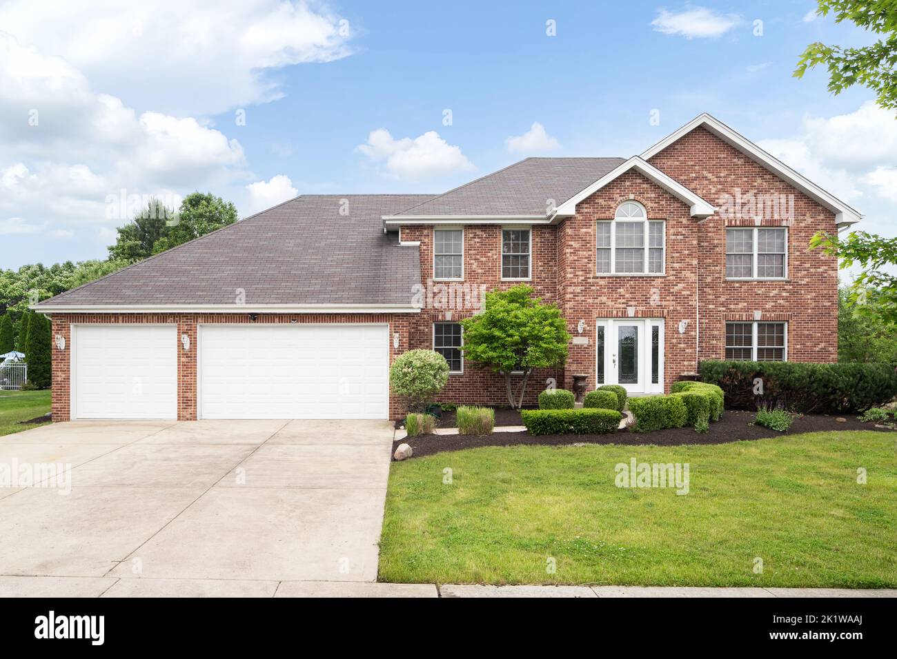 A beautiful brick home with a three car garage and beautiful ...