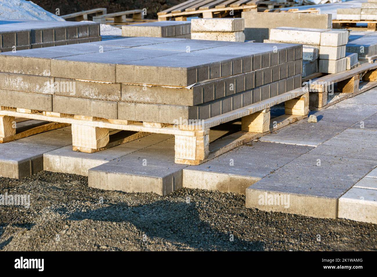 paving slabs made of artificial stone lie on pallets standing on the finished path, preparing the base and providing drainage for laying paving slabs, Stock Photo