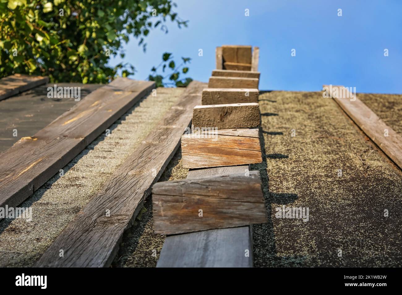 Wooden stairway to the sky. Wooden staircase on the roof of the house. Homemade wooden staircase. Stock Photo