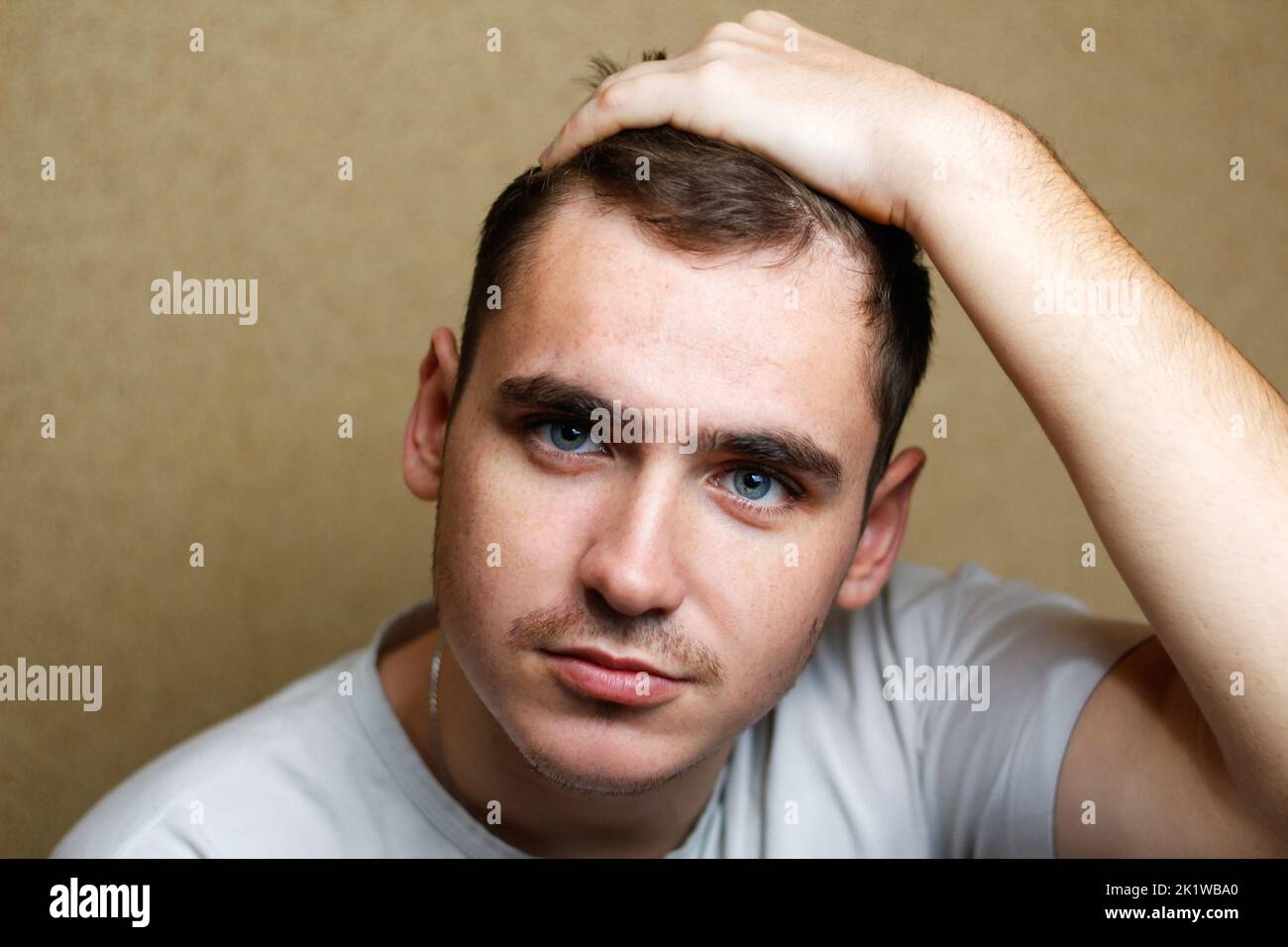 Defocus portrait of a young brunette caucasian man on yellow background posing. Handsome caucasian young man with brown hair and blue eyes. Out of foc Stock Photo