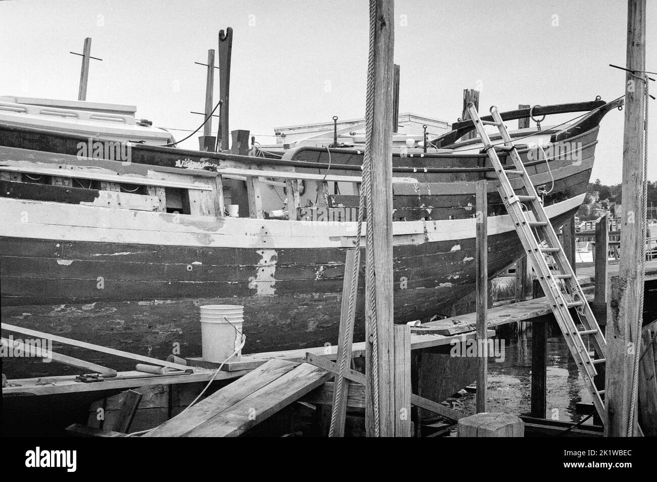 The Isabella a vintage wooden ship in drydock in Gloucester Harbor, Massachusetts. The image was captured on analog black and white film. Stock Photo