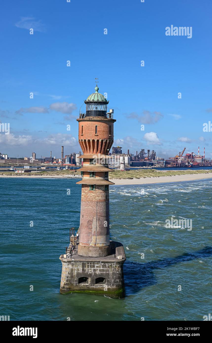 Europe, France, Dunkerque - July 9, 2022: Closeup, Feu de Saint Pol light tower hides its pier at entrance to port under blue sky. Power generation fa Stock Photo