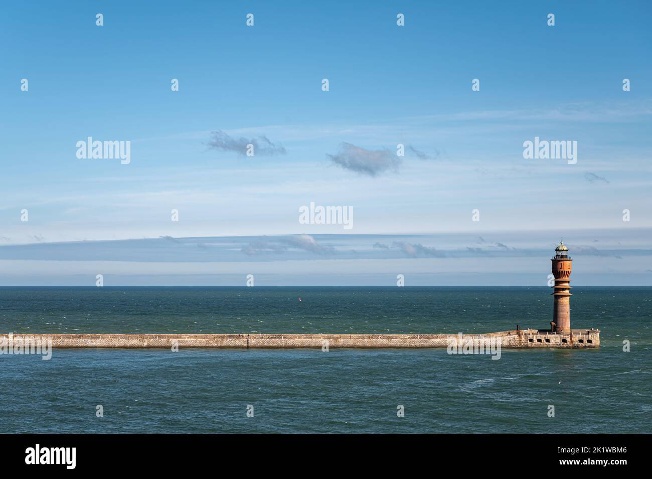 Europe, France, Dunkerque - July 9, 2022: Feu de Saint Pol, light tower, at end of its pier seen from inside harbor looking ove North Sea under blue c Stock Photo