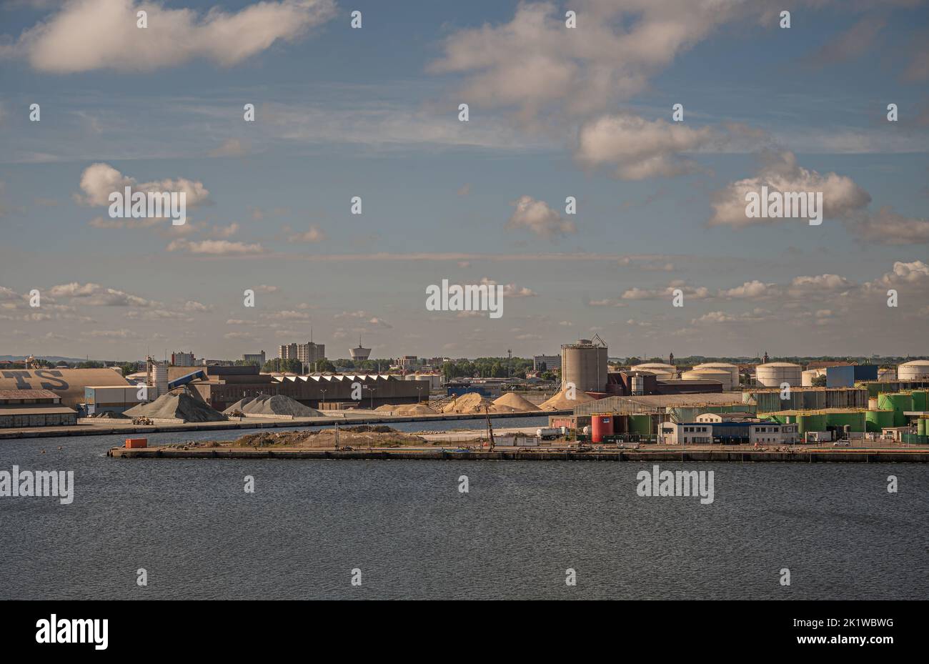 Europe, France, Dunkerque - July 9, 2022: Port scenery. Heaps on mole 4 and green tanks on mole 5 under blue cloudscape. Moles meaning docks and quays Stock Photo