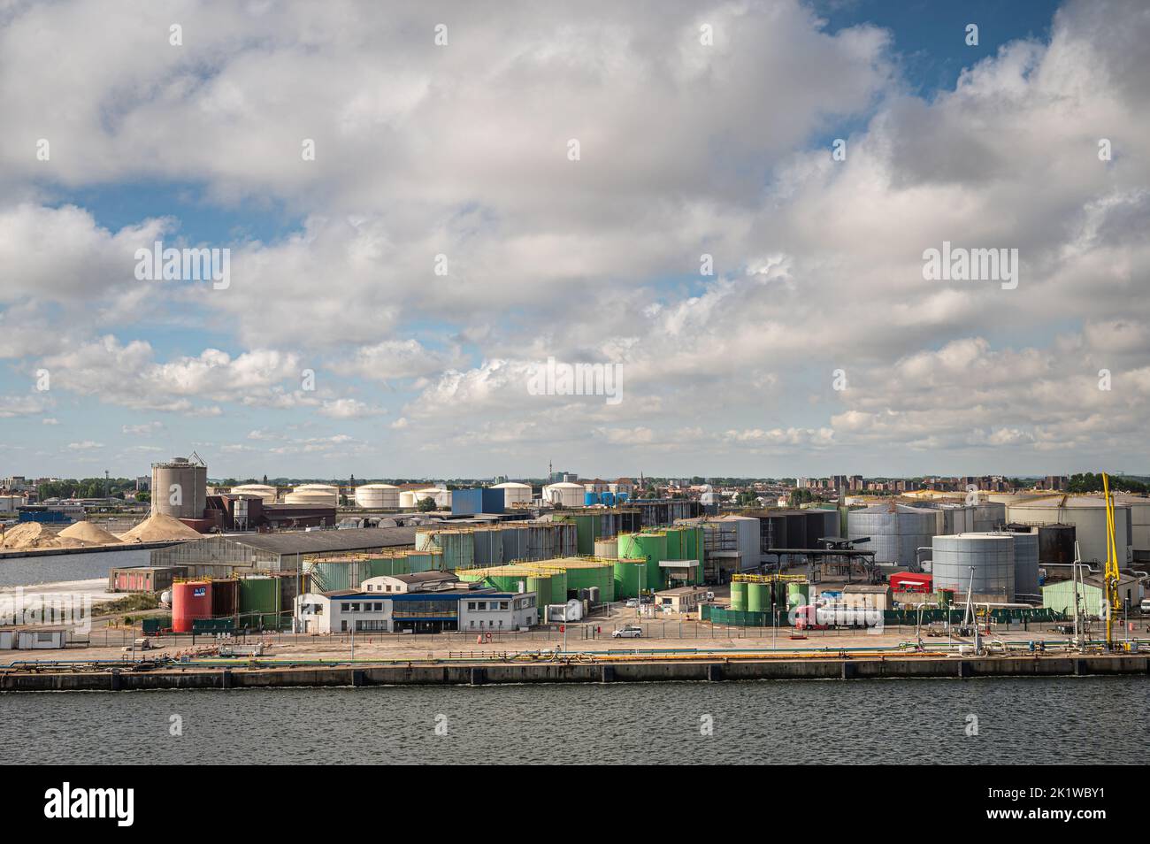 Europe, France, Dunkerque - July 9, 2022: Port scenery. Frontal, short end view onto mole 5 terminal with collection of cylindrical tanks under thick Stock Photo