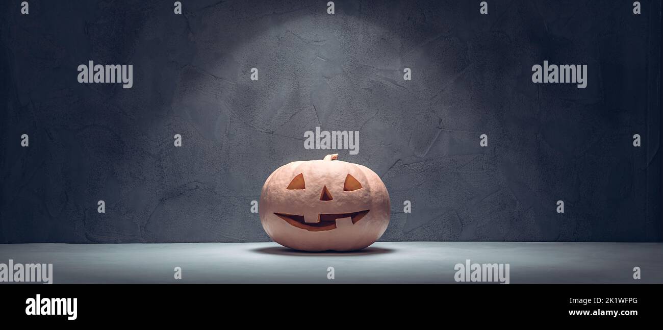 Pink Halloween pumpkin lantern in concrete stone room Stock Photo