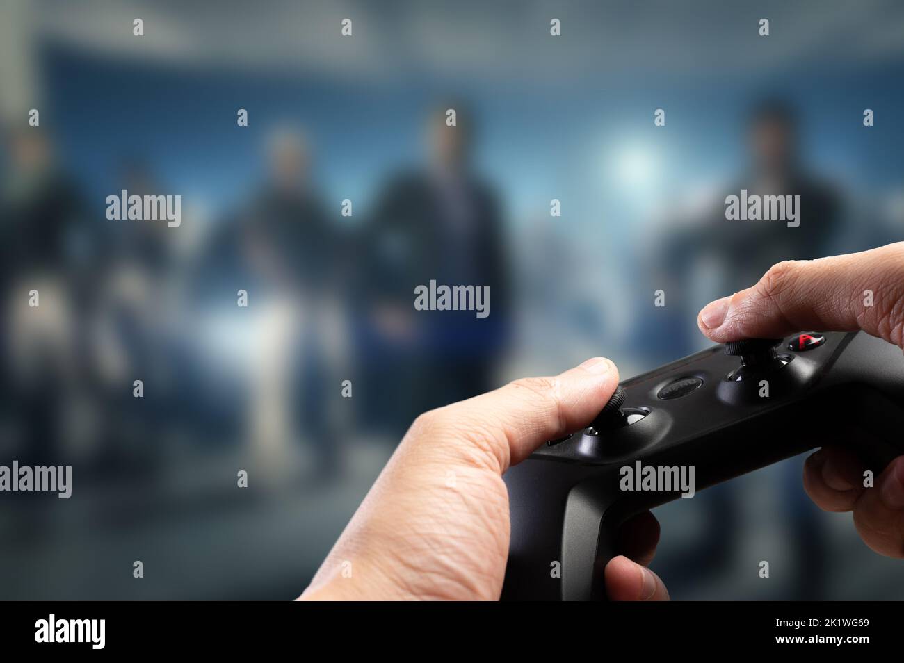 Against the background of a video game on a large screen of a plasma TV, a gamer with a GAM22ICB gamepad in his hands. Cybersport, virtual reality, mo Stock Photo