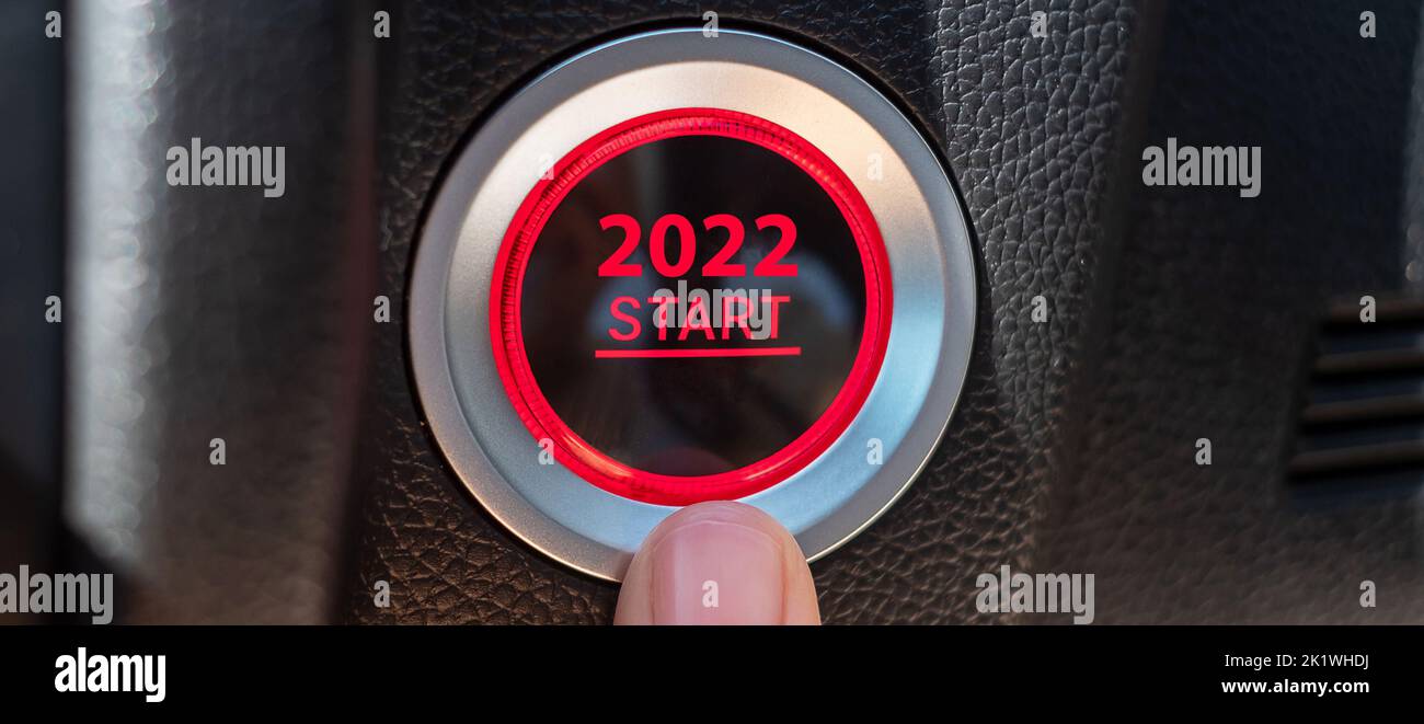 Finger press a car ignition button with 2022 START text inside modern