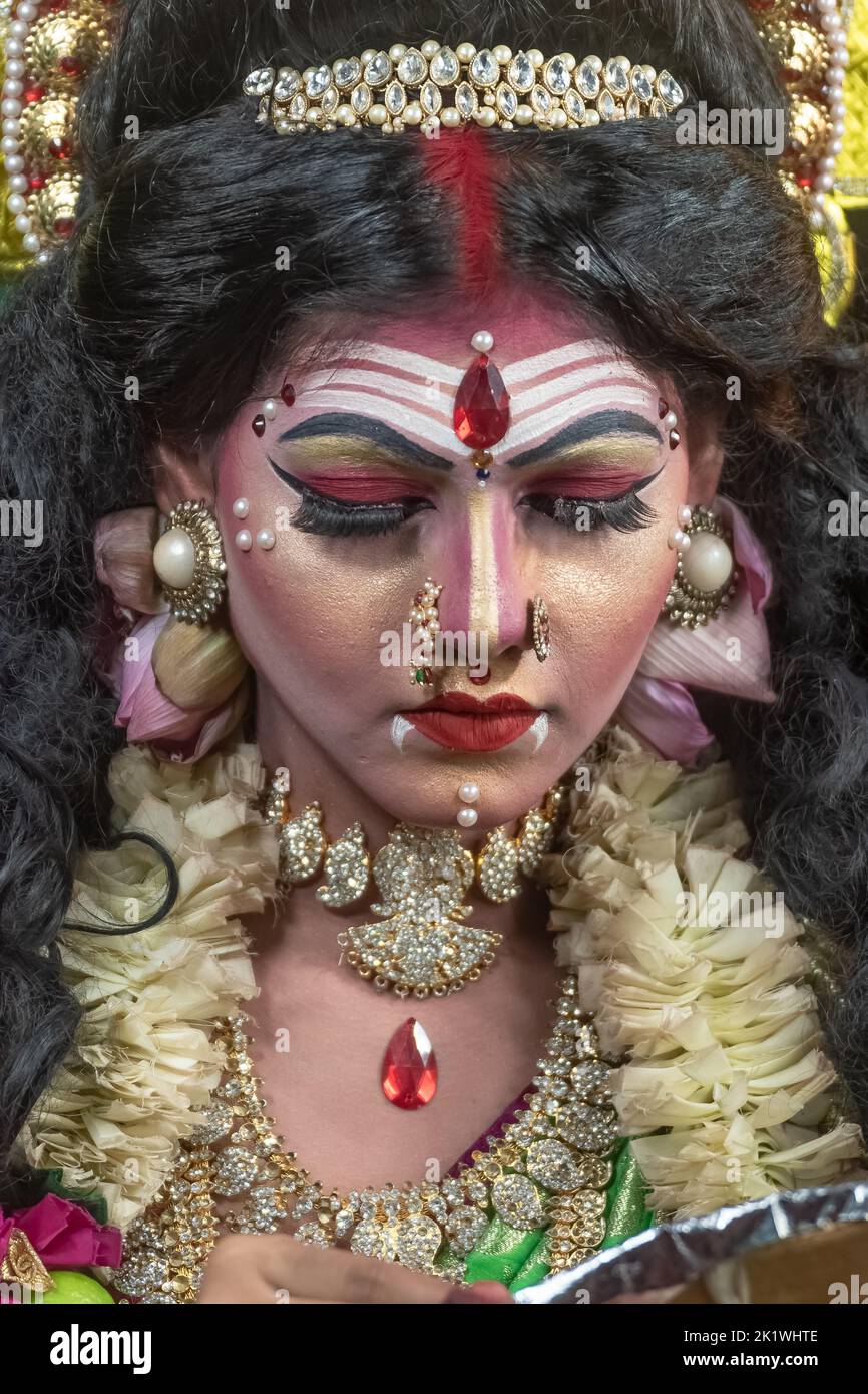 Concept Agomoni shoot with black haired Indian brunette woman face with perfect makeup and wearing jewelers with traditional dress like goddess Stock Photo