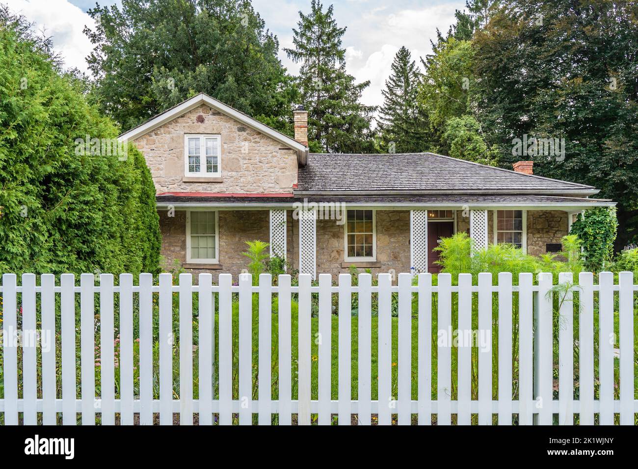 limestone house behind white fences in Guelph, Ontario, Canada Stock Photo