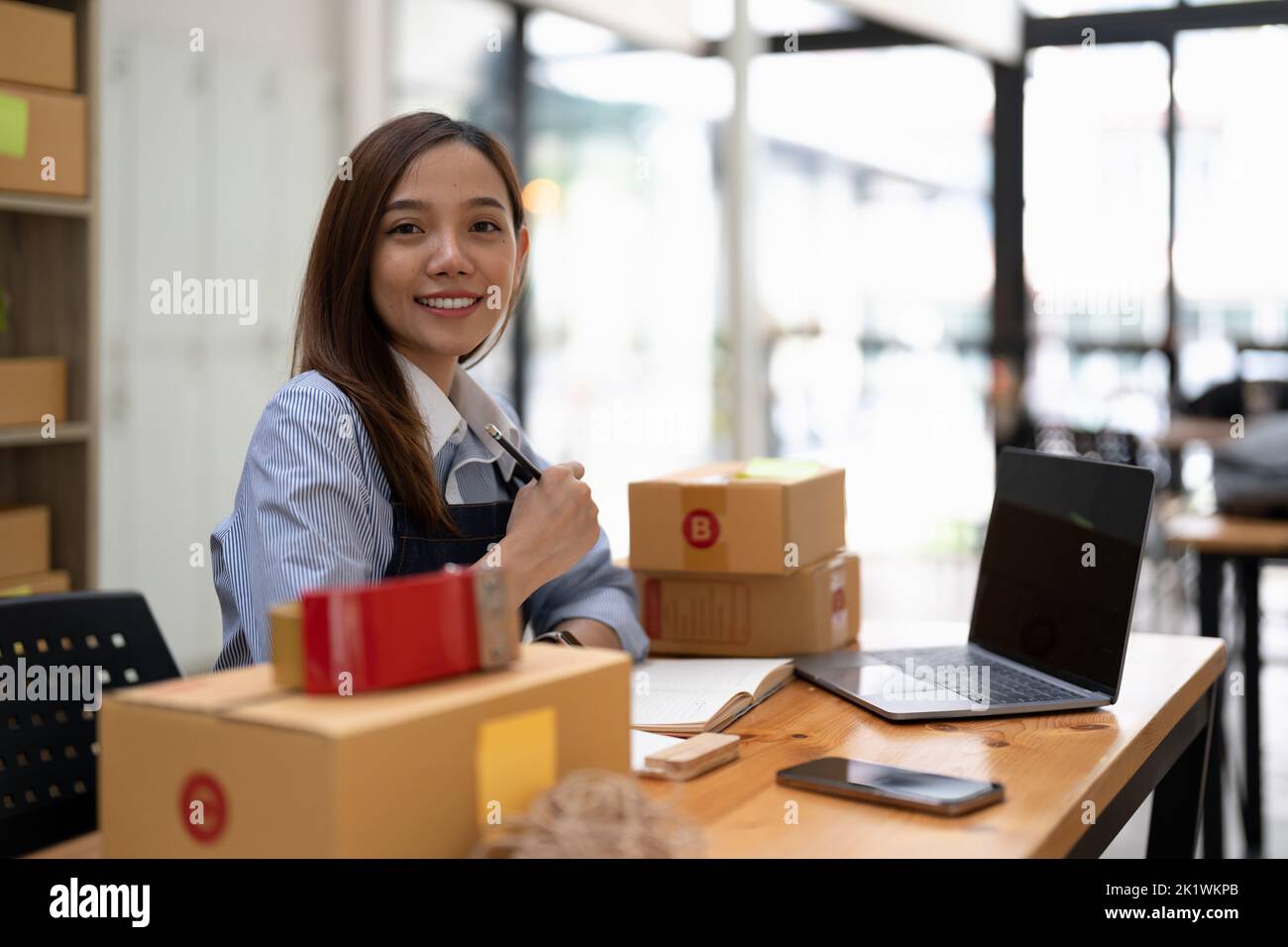 Young startup small business entrepreneur woman working with smart phone at home, Online business and delivery concept Stock Photo