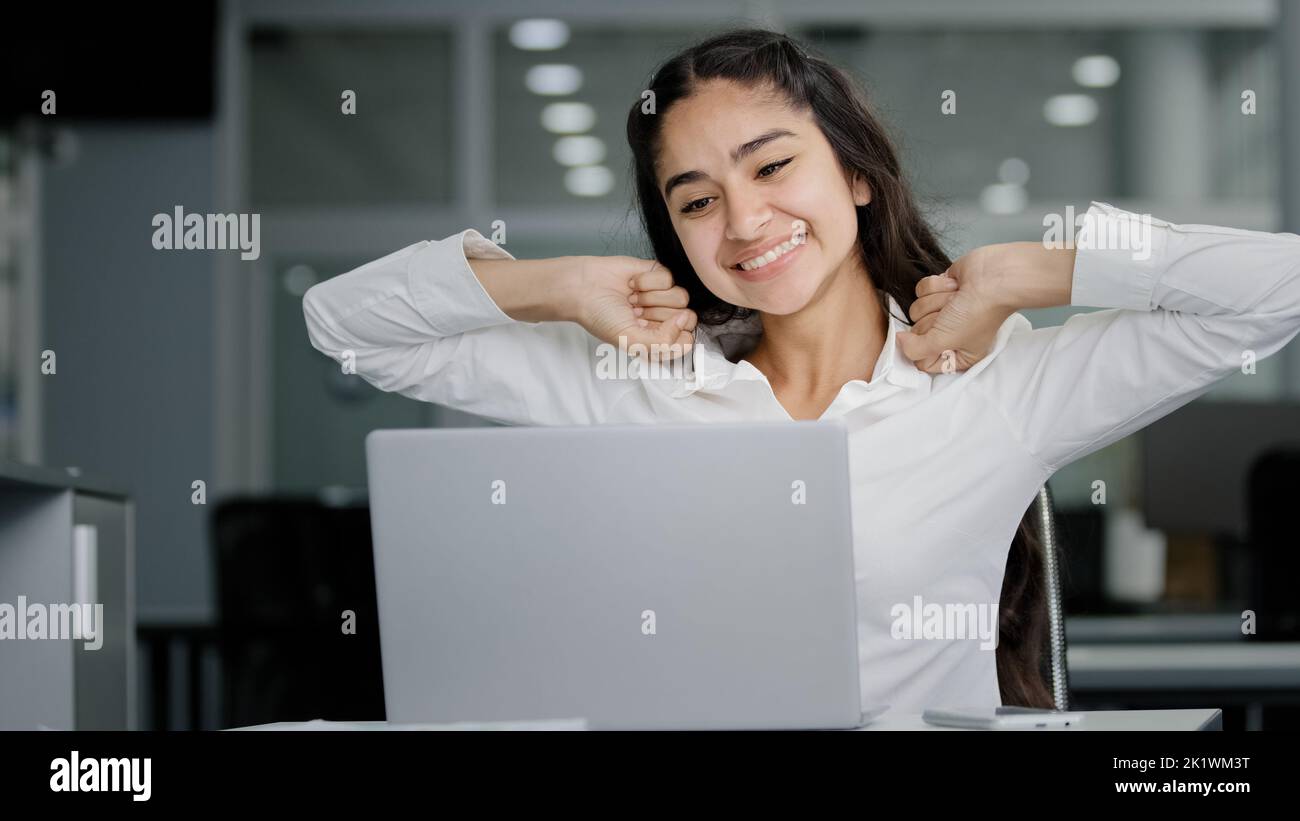 Happy funny cute young woman reading good news on laptop celebrating victory excited with great success gets new opportunities career advancement Stock Photo