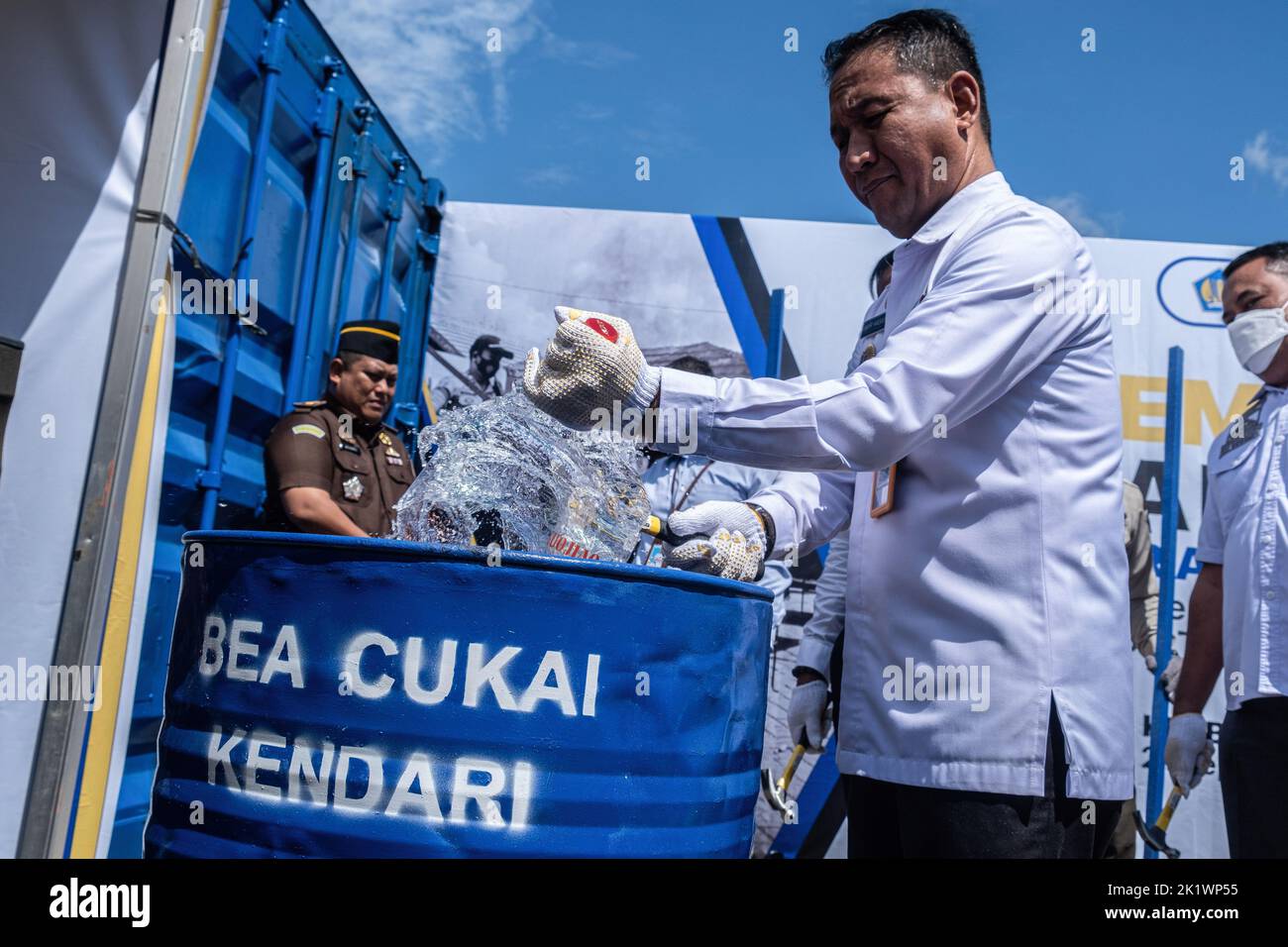 Kendari, Indonesia. 21st Sep, 2022. One of the representatives breaks the confiscated liquor bottle with a hammer. Kendari Customs in the period July to September 2022 takes action against excisable goods that do not meet the provisions of the law originating from targeting, market operations, land and sea patrols. The goods resulting from the prosecution are then designated as state property (BMN) and have received approval from the Office of the State Property and Auction Service (KPKNL) to be destroyed. Credit: SOPA Images Limited/Alamy Live News Stock Photo