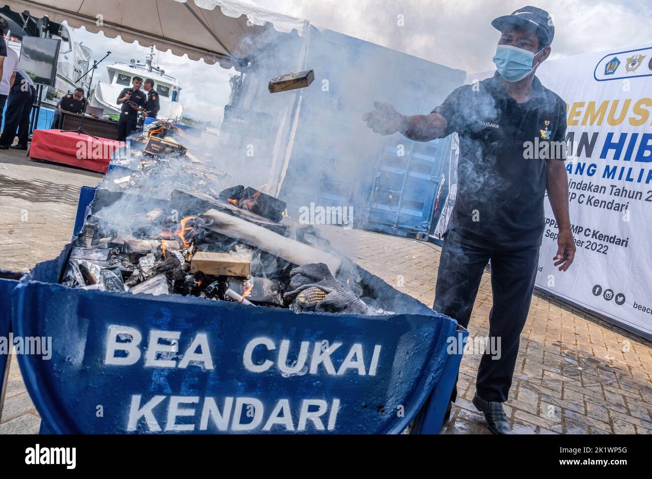 Kendari, Indonesia. 21st Sep, 2022. Officers throw cigarettes into containers for the destruction of evidence that has been burned. Kendari Customs in the period July to September 2022 takes action against excisable goods that do not meet the provisions of the law originating from targeting, market operations, land and sea patrols. The goods resulting from the prosecution are then designated as state property (BMN) and have received approval from the Office of the State Property and Auction Service (KPKNL) to be destroyed. Credit: SOPA Images Limited/Alamy Live News Stock Photo