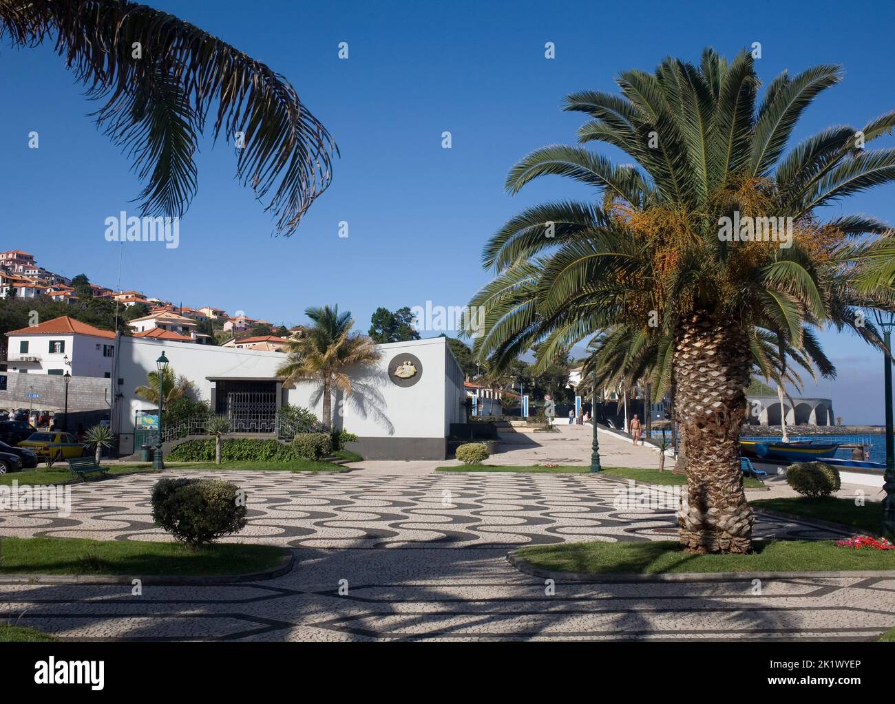 park with palm trees and decorative paved tiles adjacent to Palmeiras beach in Santa Cruz Madeira Stock Photo