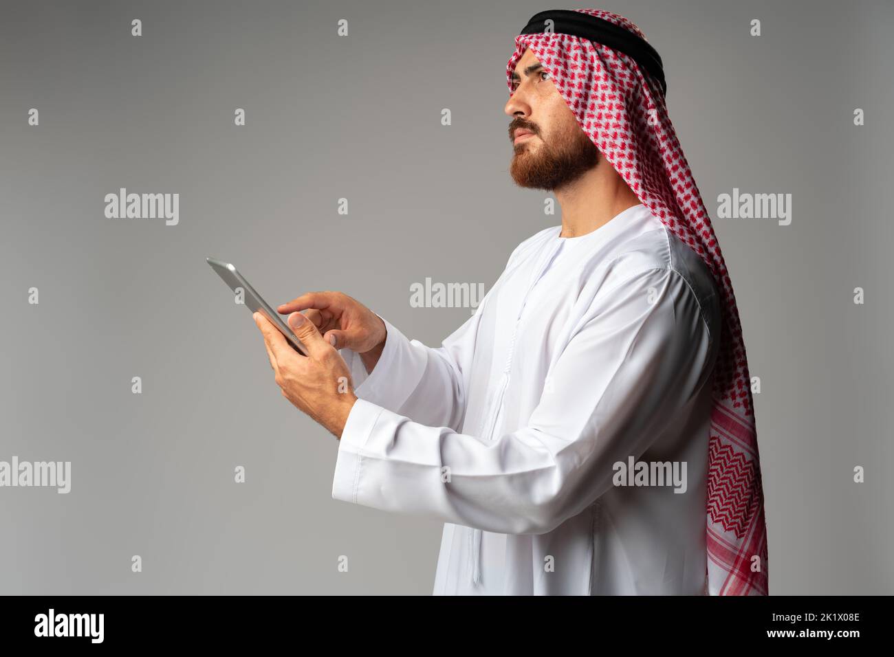 Arab businessman using digital tablet on gray background Stock Photo