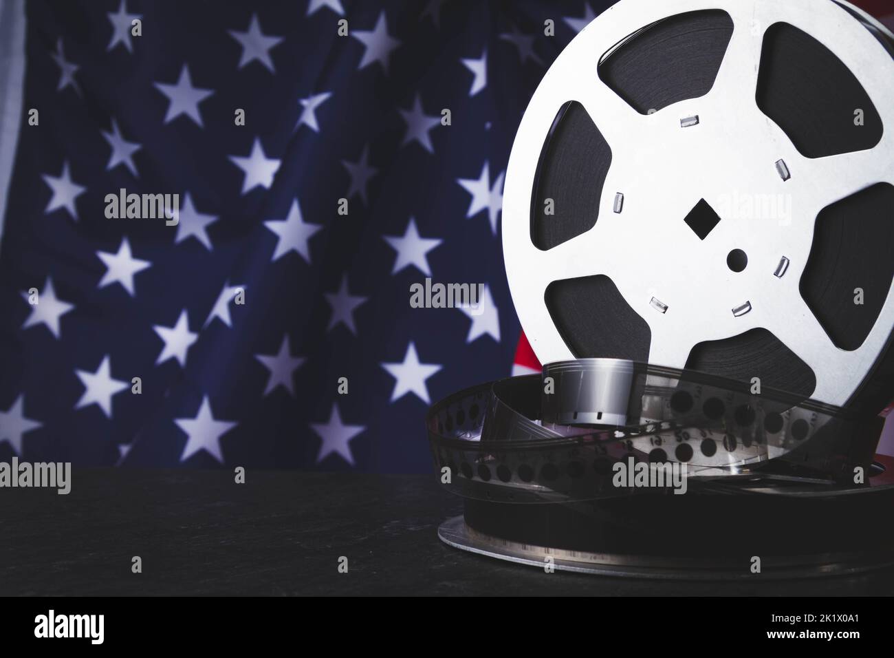 American cinema. Cinematography in the USA. Old film reel on the background of the flag of America. Stock Photo