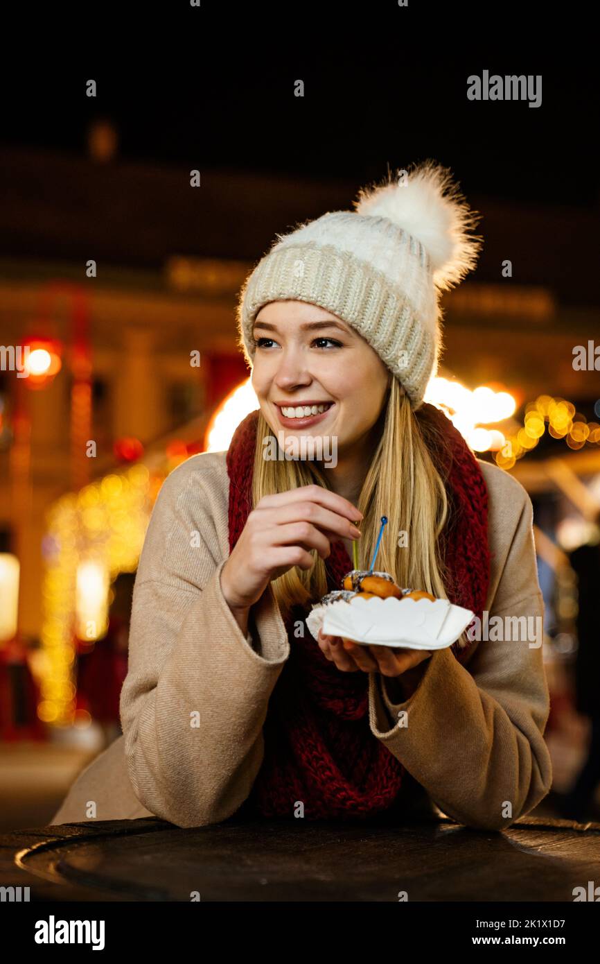 Portrait Of Happy Young Woman Eating Donuts On The Christmas Market Holiday Fun People Concept 5675