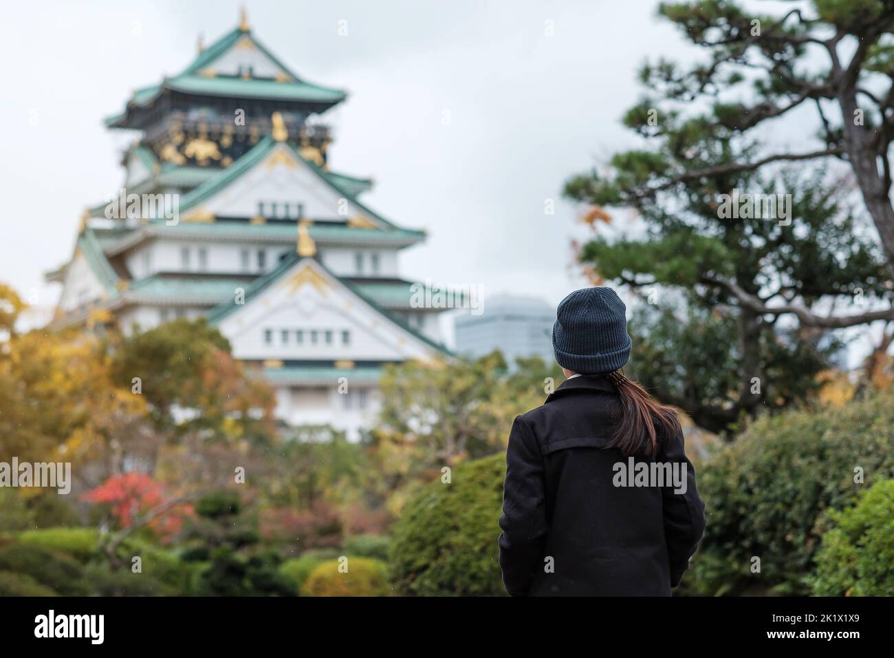 solo woman tourist trveling at Osaka castle in Autumn season, Asian traveler visit in Osaka city, Japan. Vacation, destination and travel concept Stock Photo