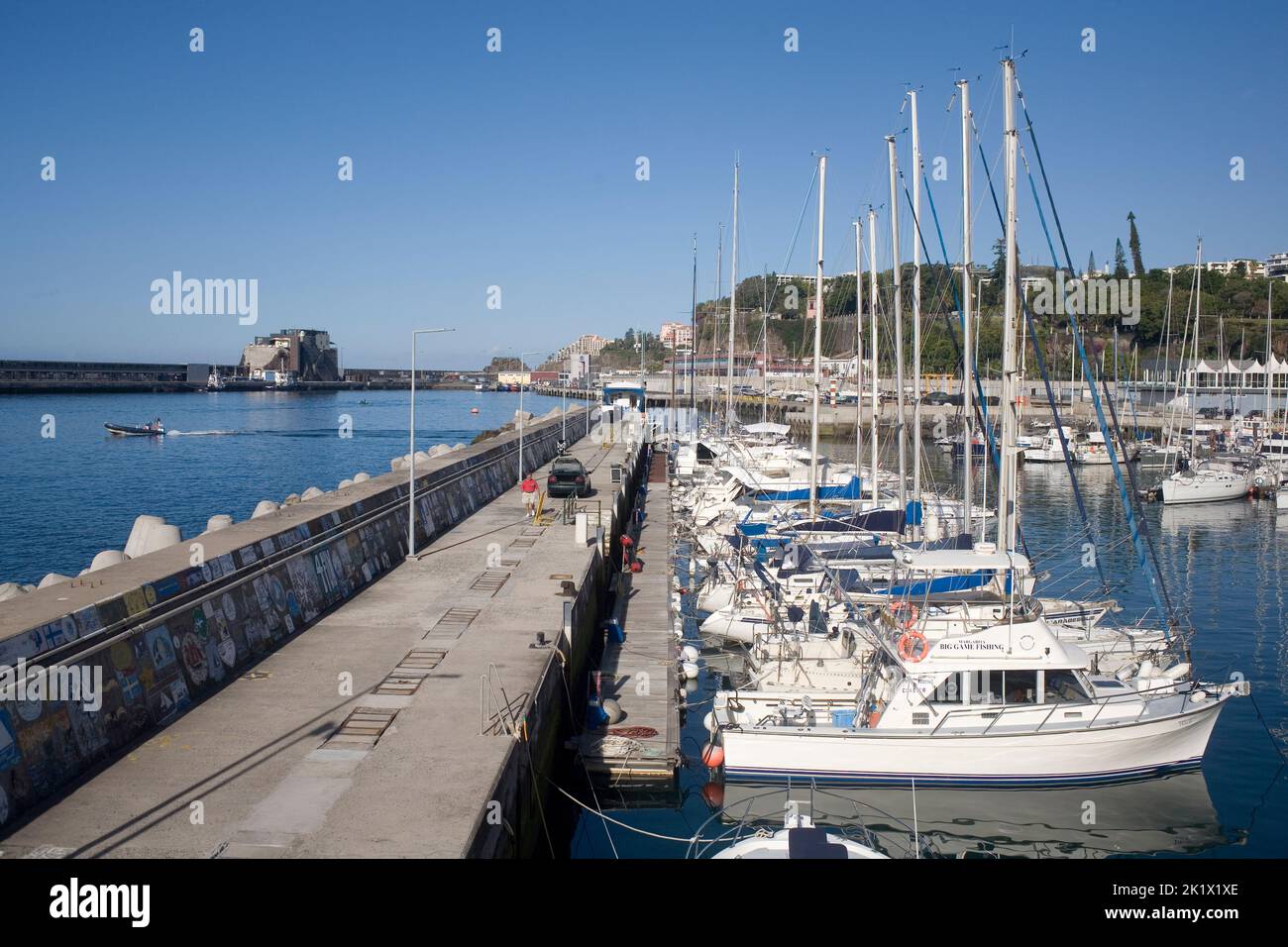 wall between marina and harbour and moored boats in Funchal Madeira Stock Photo